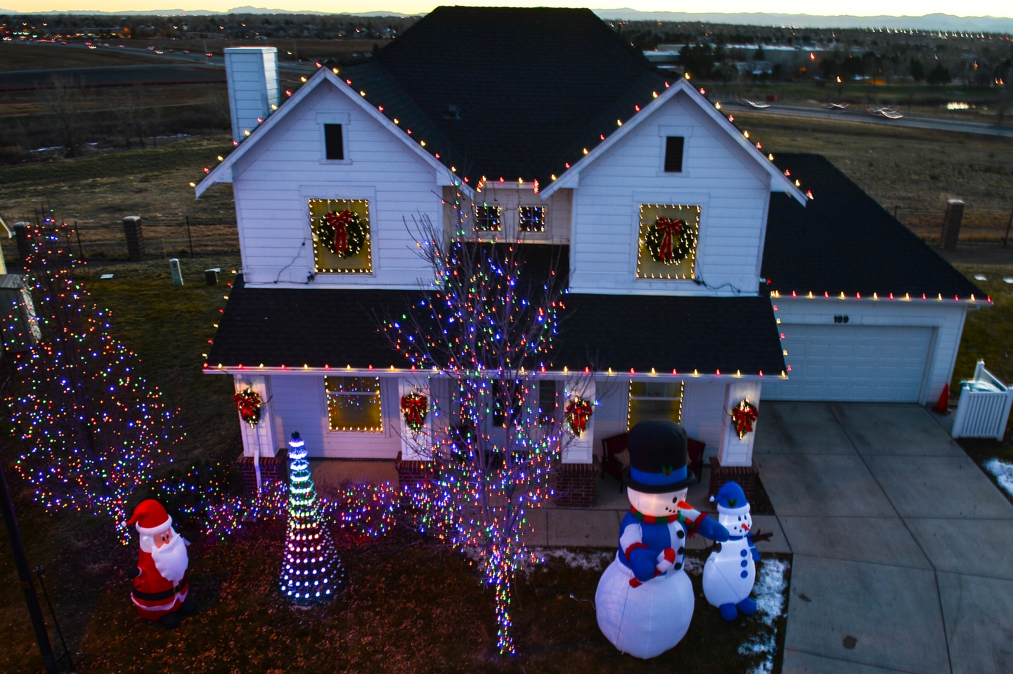 Maj. Matthew Anderson, 460th Civil Engineer Squadron, and his family were surprised with a visit from Christmas Decor by Swingle Lawn, Tree & Landscape Care Nov. 29, 2013, in family housing on Buckley Air Force Base, Colo. The Andersons applied and were selected for the Decorated Family Program, which provided lights, wreaths and other ornaments applied by a professional decorating team to military members and families. (U.S. Air Force photo by Senior Airman Riley Johnson/Released)