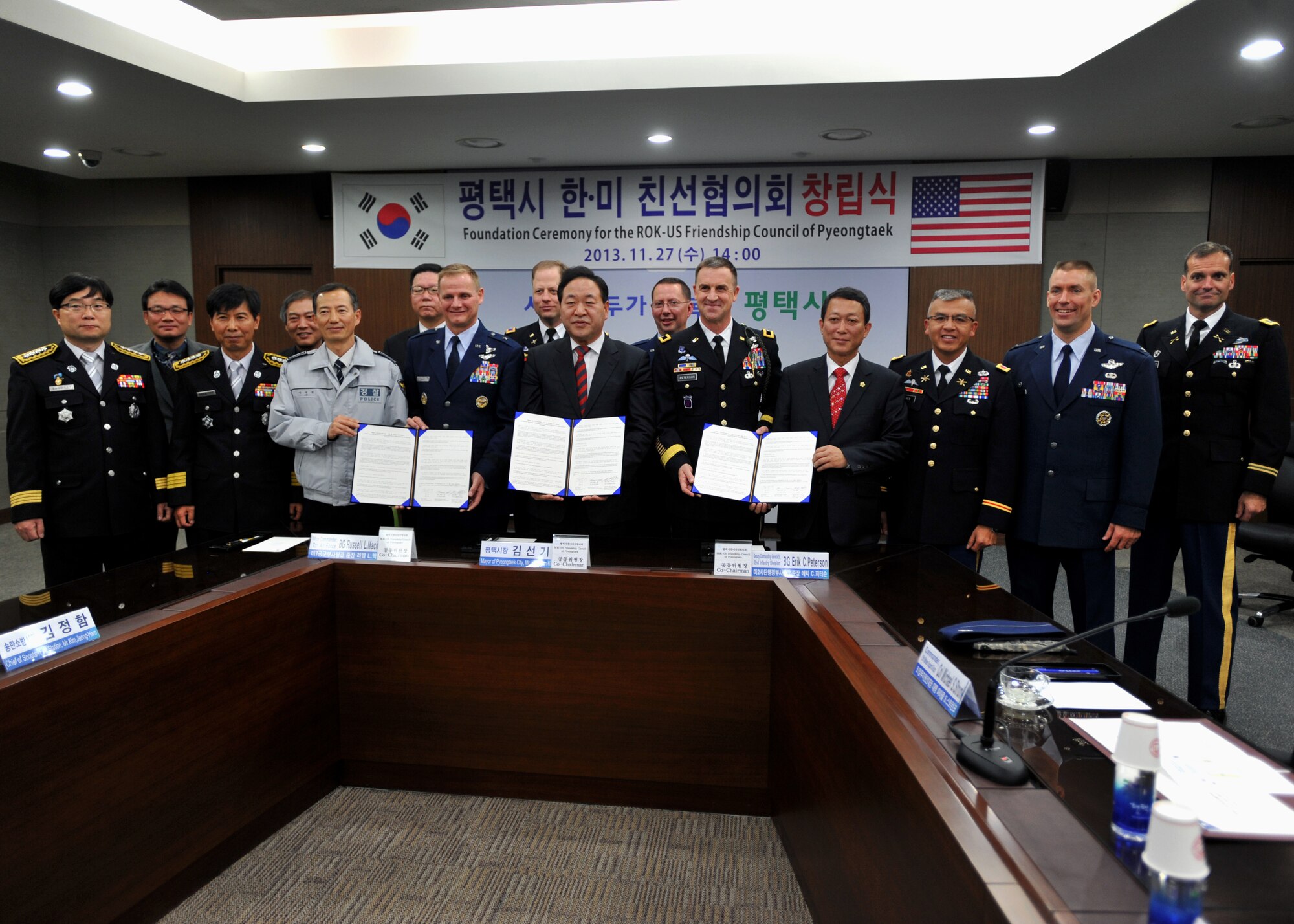 Members of the Republic of Korea-U.S. Friendship Council of Pyeongtaek pose for a photo with the signed council agreement during the foundation ceremony at Pyeongtaek City, ROK, Nov. 27, 2013. The agreement states that the council will endeavor to coordinate and/or come up with appropriate measures for any issues related to common interests of U.S. Forces Korea and the local community. (U.S. Air Force photo/Senior Airman Siuta B. Ika)