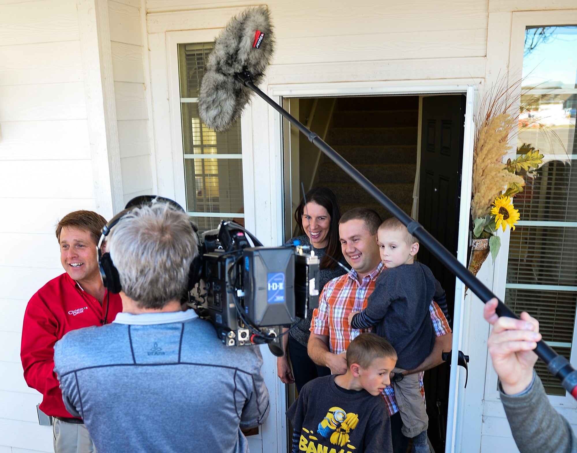 Christmas Decor by Swingle Lawn, Tree & Landscape Care decorators and an NBC camera crew surprise Maj. Matthew Anderson, 460th Civil Engineer Squadron, and his family Nov. 29, 2013, in family housing on Buckley Air Force Base, Colo. The Andersons applied and were selected for the Decorated Family Program, which provided lights, wreaths and other ornaments applied by a professional decorating team to military members and families. (U.S. Air Force photo by Senior Airman Riley Johnson/Released)