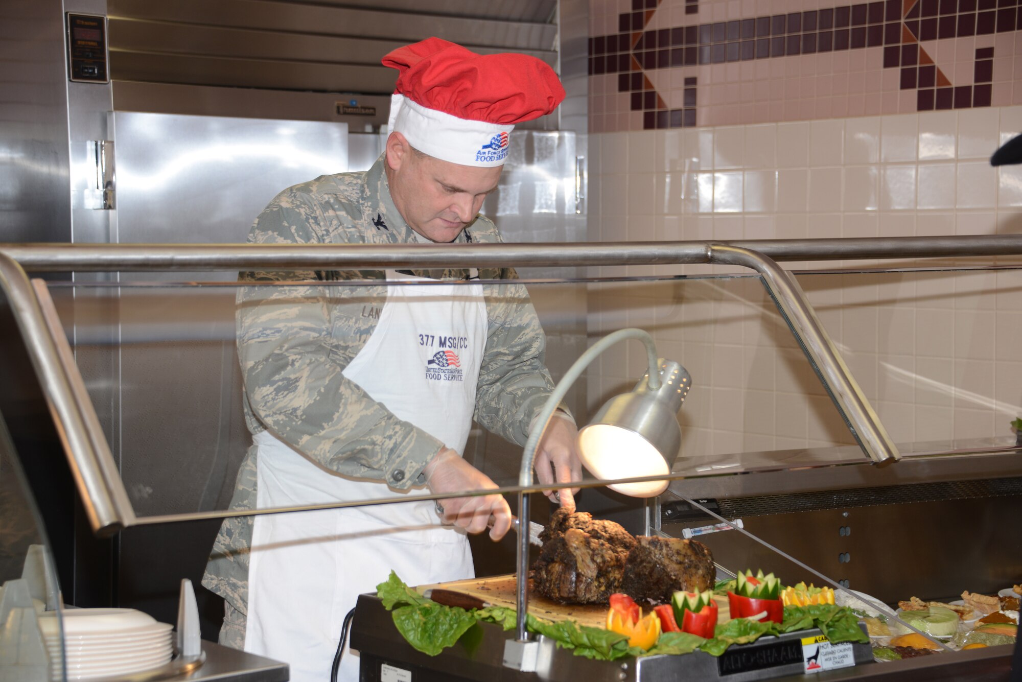 Col. Jeffrey Lanning, 377th Mission Support Group commander, slices roast beef in preparation for the Thanksgiving meal at the Kirtland Dining Facility.  Senior leaders were at the facility Thanksgiving Day to serve dinner to Airmen and retirees. (Photo by Dennis Carlson)