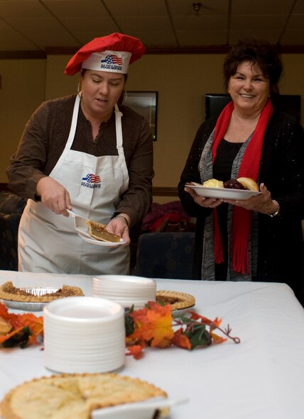 Allison LeMire, wife of Lt. Col. Justin LeMire, 436th Training Squadron commander, serves pie to an attendee of Team Dyess’ annual Thanksgiving Day dinner Nov. 28, 2013, at Dyess Air Force Base, Texas. Because of ongoing facility upgrades at Longhorn Dining Facilty, this was the first time the meal was served outside of the dining facility. (U.S. Air Force photo by Senior Airman Peter Thompson/Released)