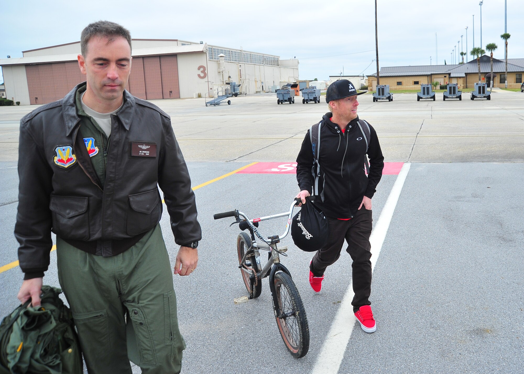 Lt. Col. Joe Granducci, 325th Training Support Squadron assistant director of operations, and his brother-in-law, Tom “Fuzzy” Hall, professional BMX rider, exit the flightline after “Fuzzy” performed several tricks in front of his brother-in-law’s T-38 Talon. (U.S. Air Force photo by Airman 1st Class Dustin Mullen)