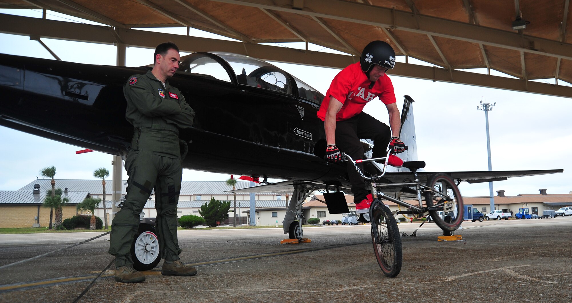 Tom “Fuzzy” Hall, professional BMX rider, performs a “Tail Whip” in front of a T-38 Talon, as his brother-in-law, Lt. Col. Joe Granducci, 325th Training Support Squadron assistant director of operations, looks on. (U.S. Air Force photo by Airman 1st Class Dustin Mullen)