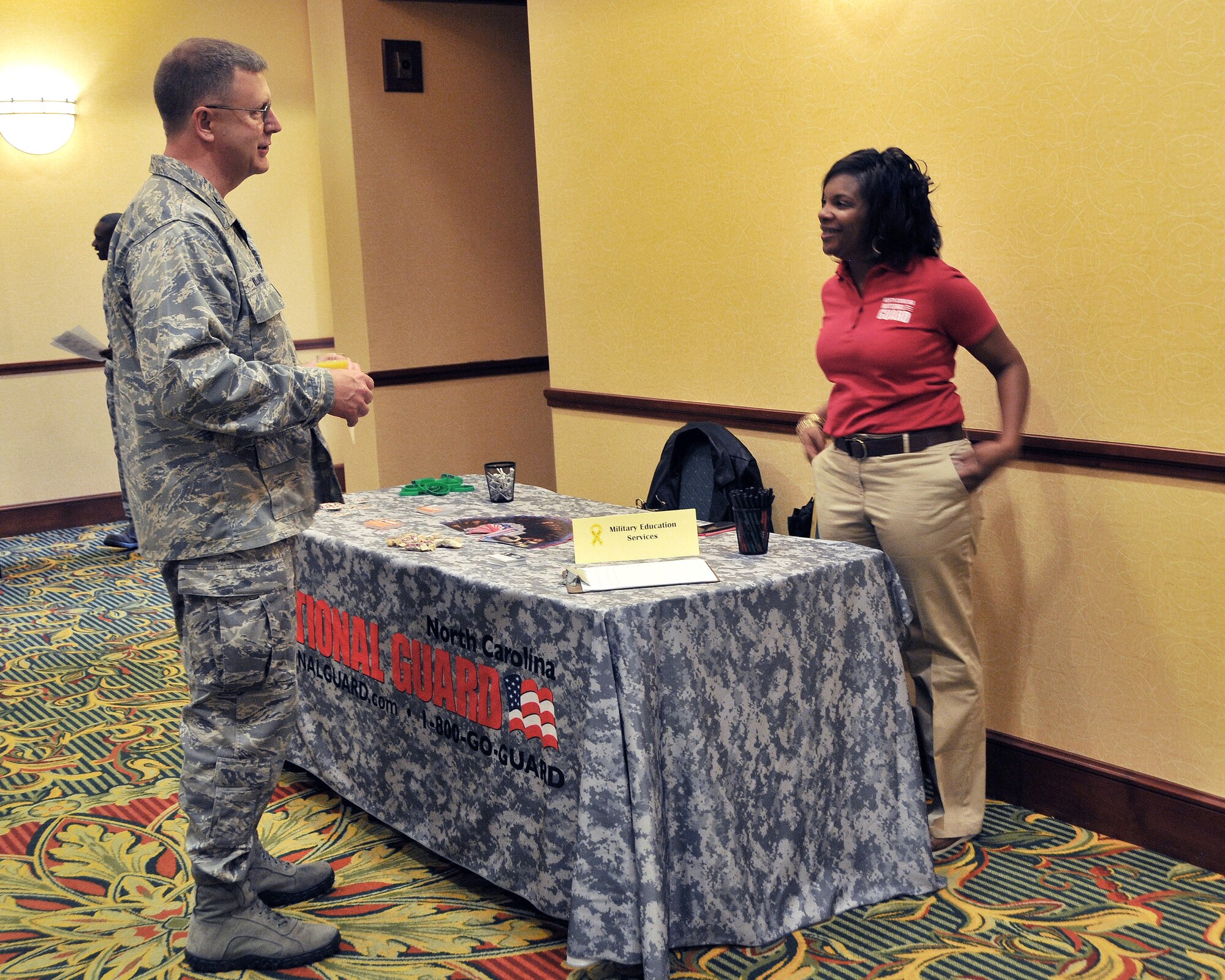 U.S. Air Force Col. Roger E. Williams  Jr., commander, 145th Airlift Wing, North Carolina Air National Guard, talks with a representative from Military Education Services after welcoming airmen and their families to the first ever North and South Carolina ANG joint Yellow Ribbon Reintegration Program event.  During deployments, the member is gone and focused on their mission. Through the support of the Wing Commander and the YR Program, Airman can be assured that their families are taken care of while they are away.  During this one-day event, Airmen learn about entitlements and what is available for their families in the member's absence.  This YR event was held Charlotte, N.C., November 16, 2013. (Air National Guard photo by Master Sgt. Patricia F. Moran/Released)