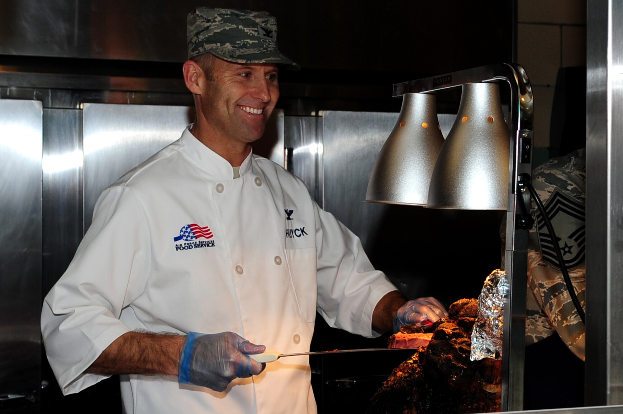 U.S. Air Force Col. Kevin Huyck, 1st Fighter Wing commander, slices roast beef during the Thanksgiving Day meal at the Crossbow Dining Facility at Langley Air Force Base, Va., Nov. 28, 2013. Huyck joined fellow Langley leaders to serve a traditional holiday meal to Service members and their families.  (U.S. Air Force photo by Airman Areca T. Wilson/Released)