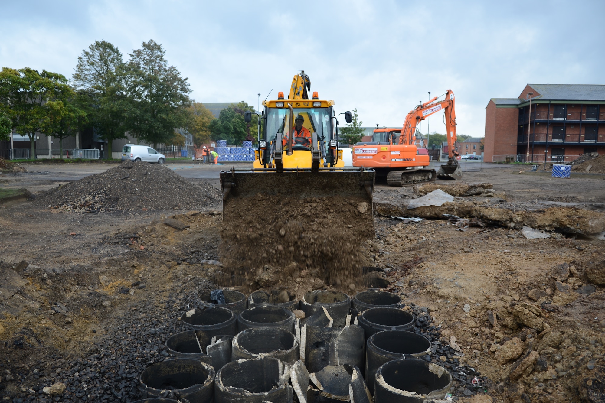 A bulldozer fills in a drainage ditch Oct. 16, 2013, in a parking lot on RAF Mildenhall, England, during a demolition. The parking lot was removed to prepare the area for a grass field, which will provide a new area for Airmen to hold events. (U.S. Air Force photo by Airman 1st Class Dillon Johnston/Released)