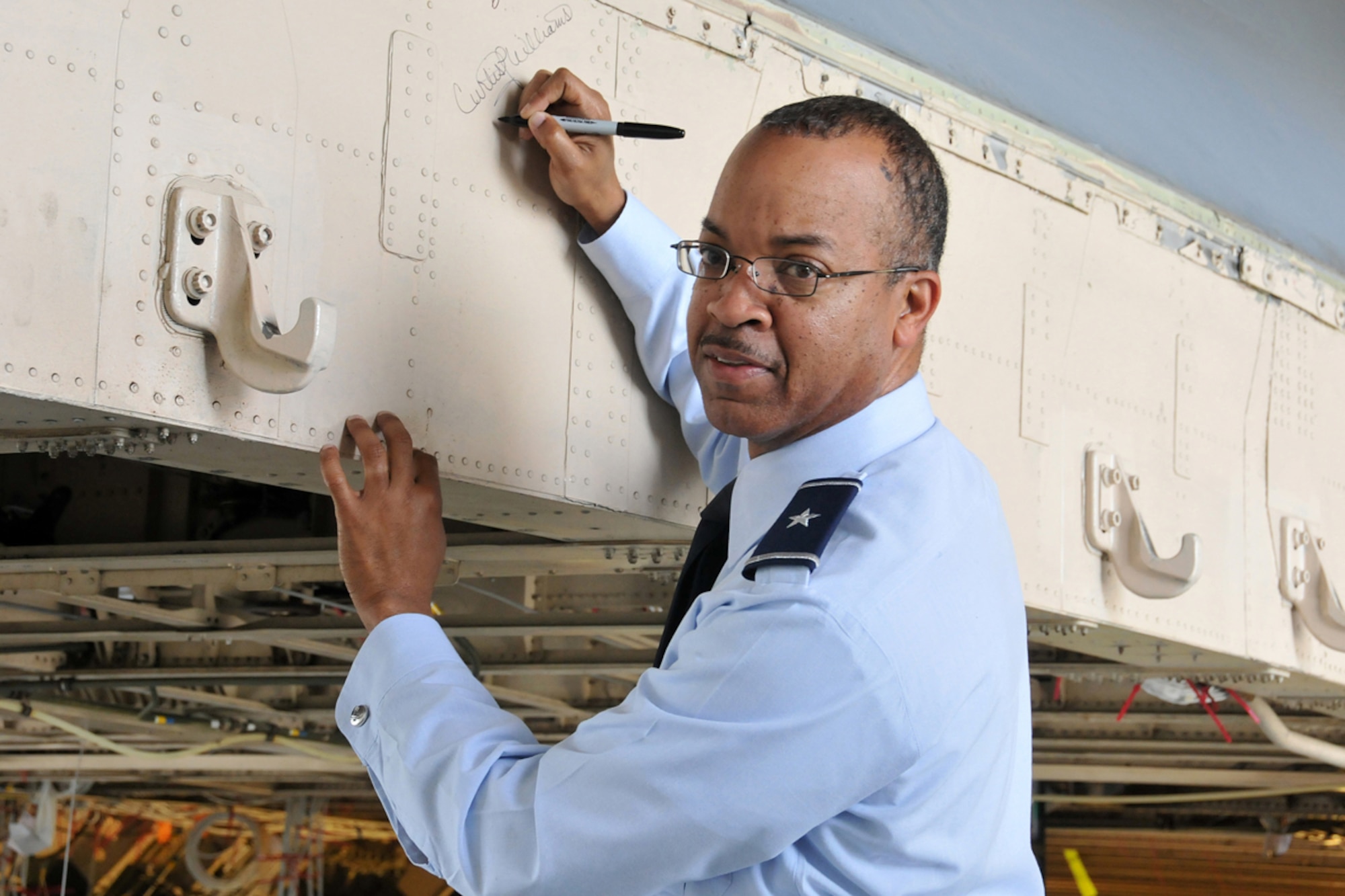 Brig. Gen. Curtis Williams, 22nd Air Force vice commander, autographs a C-5 aircraft during a recent tour of Lockheed Martin Marietta Plant 6. (U.S. Air Force photo/Senior Airman Elizabeth Van Patton) 