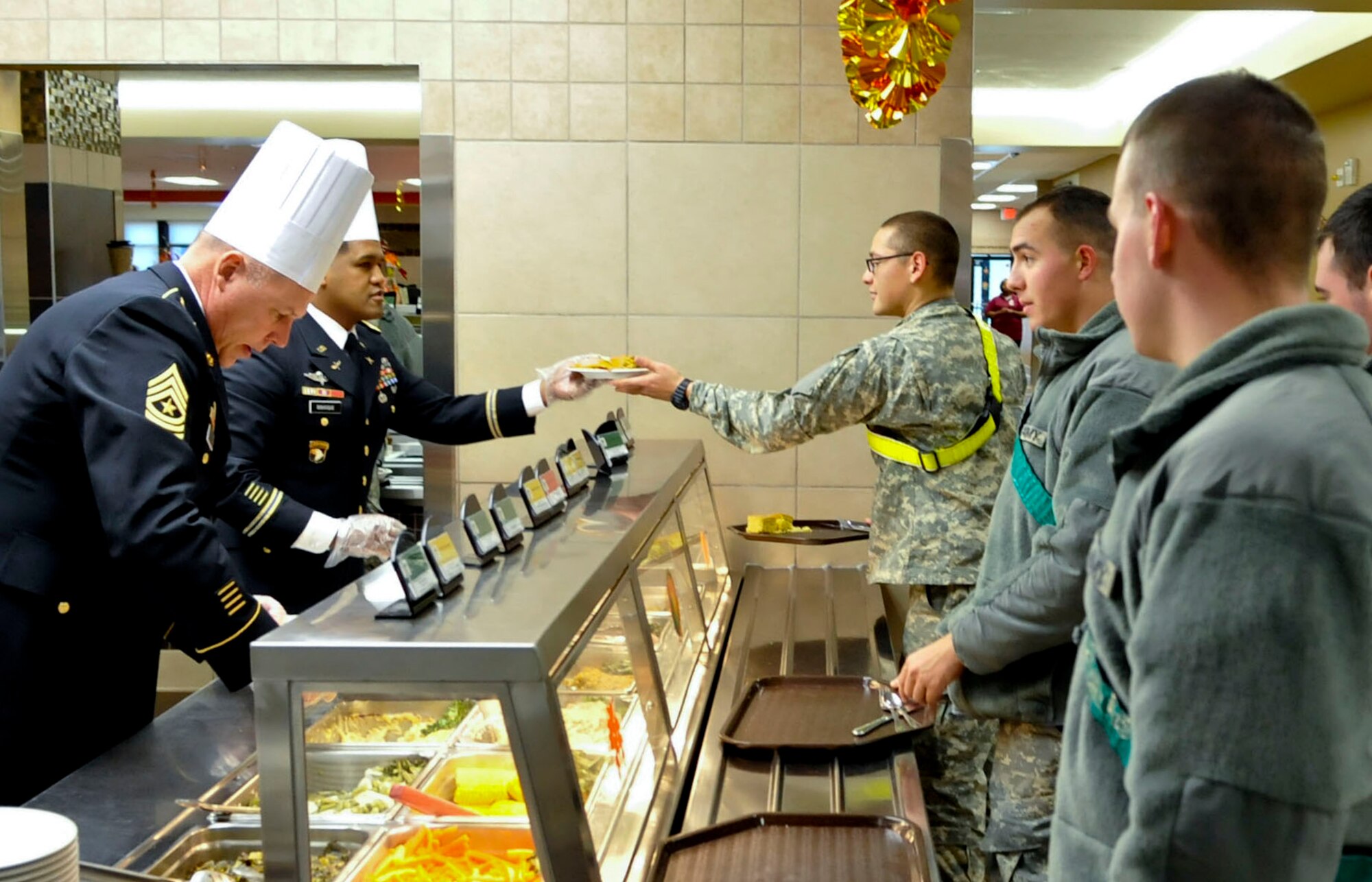 From left, U.S. Army Sgt. Maj. William Platt, 128th Aviation Brigade sergeant major, and Lt. Col. Benjamin Bahoque, 128th Avn. Bde. deputy commanding officer, serve Soldiers a Thanksgiving meal at Fort Eustis, Va., Nov. 28, 2013. As part of a continued tradition, members of Fort Eustis’ leadership serve holiday meals to Soldiers who are unable to go home for the holidays. (U.S. Air Force photo by Staff Sgt. Wesley Farnsworth/Released)