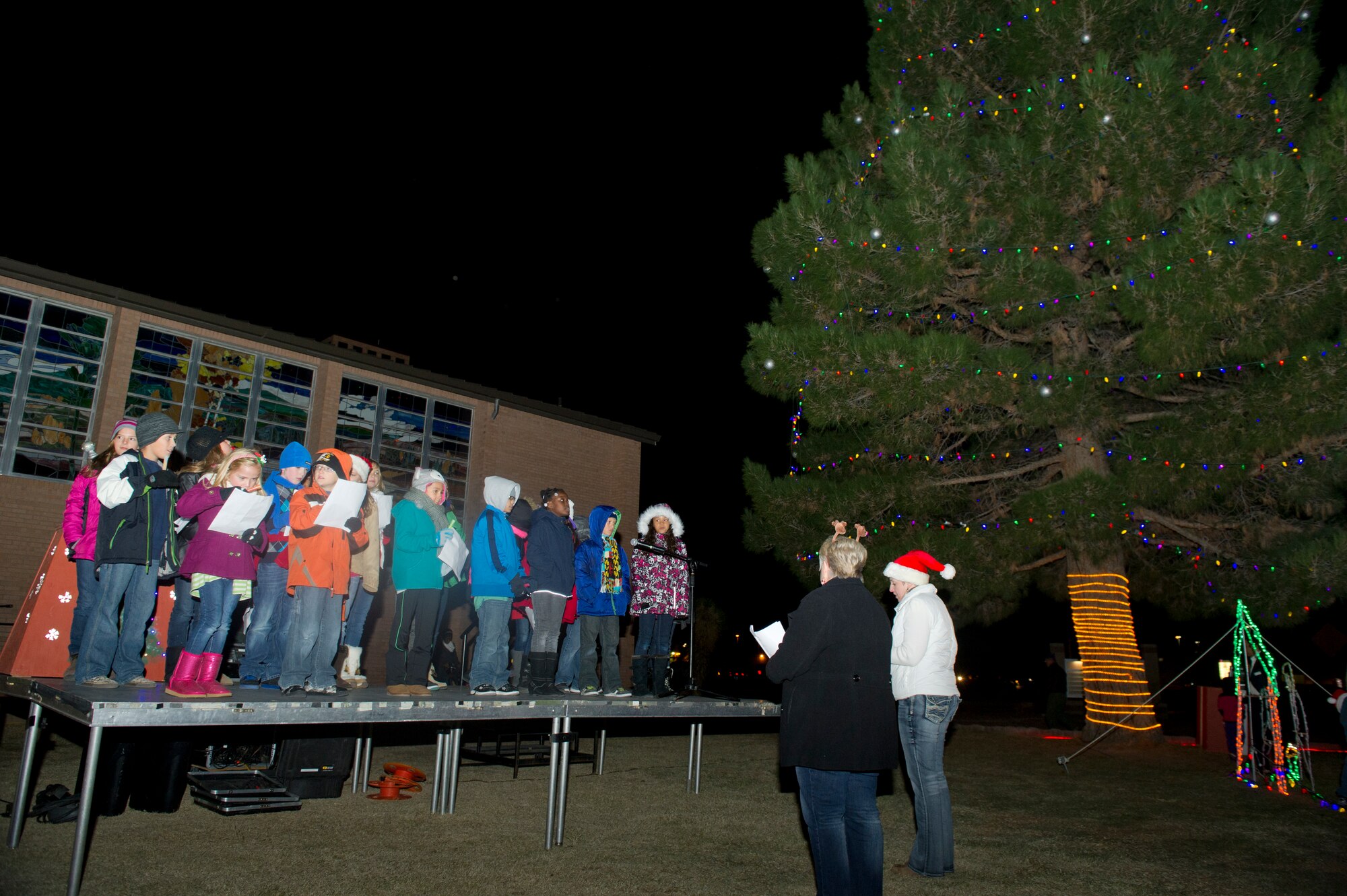 Members of Team Holloman gather for the annual Christmas tree and Menorah lighting ceremony at which Savannah Berry, a former contestant on The Voice, preformed holiday songs followed by young members of the church choir at Holloman Air Force Base N.M., Nov. 22.  Berry also performed at the 49th Wing holiday party later that evening.(U.S. Air Force photo by Airman 1st Class Chase Cannon/Released)