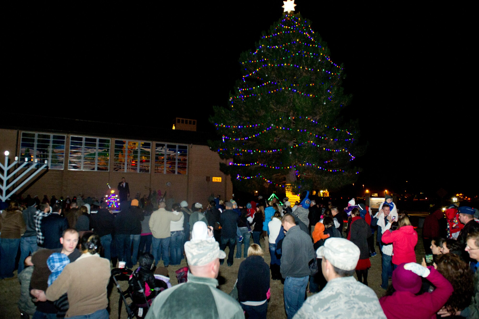 Members of Team Holloman gather for the annual Christmas tree and Menorah lighting ceremony at which Savannah Berry, a former contestant on The Voice, preformed holiday songs followed by young members of the church choir at Holloman Air Force Base N.M., Nov. 22.  Berry also performed at the 49th Wing holiday party later that evening.(U.S. Air Force photo by Airman 1st Class Chase Cannon/Released)