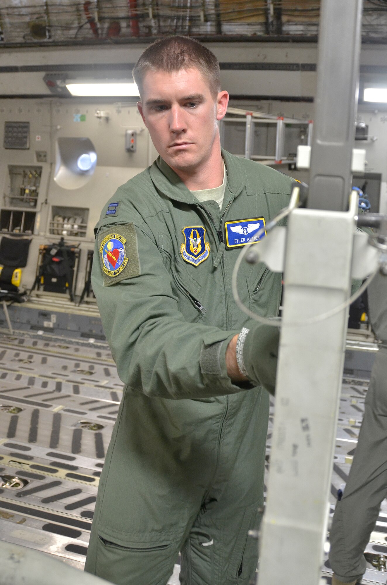 WRIGHT-PATTERON AIR FORCE BASE, Ohio - Capt. Tyler Altier, 445th Aeromedical Evacuation Squadron, flight nurse, helps break down stanchions onboard a 445th Airlift Wing C-17 Globemaster III upon landing after a local training flight Nov. 16. AES flies local missions, cross-country missions, and operational missions. In a four-month rotation, Airmen fly approximately 25-100 missions, as well as supporting static missions to demonstrate their jobs to groups such as Scouts and civic leaders. (U.S. Air Force photo/Staff Sgt. Amanda Duncan)