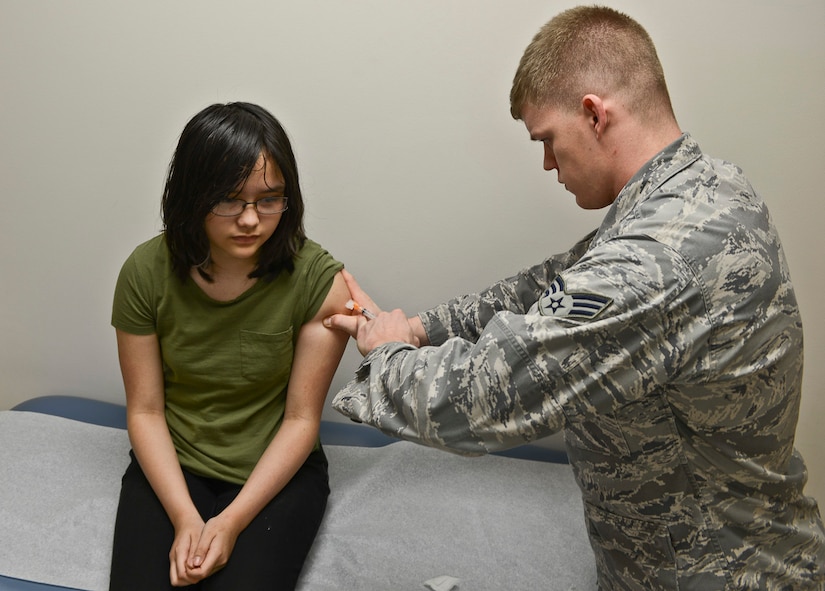 Rachel Brittain, 12, from Newport News, Va., receives a flu shot from U.S. Air Force Senior Airman Justin Johannes, 633rd Medical Operations Squadron immunizations backup technician, at Langley Air Force Base, Va., Nov. 25, 2013. Vaccinating children helps protect against various diseases, and is required to use base facilities such as the Child Development Center. (U.S. Air Force photo by Senior Airman Connor Estes/Released)