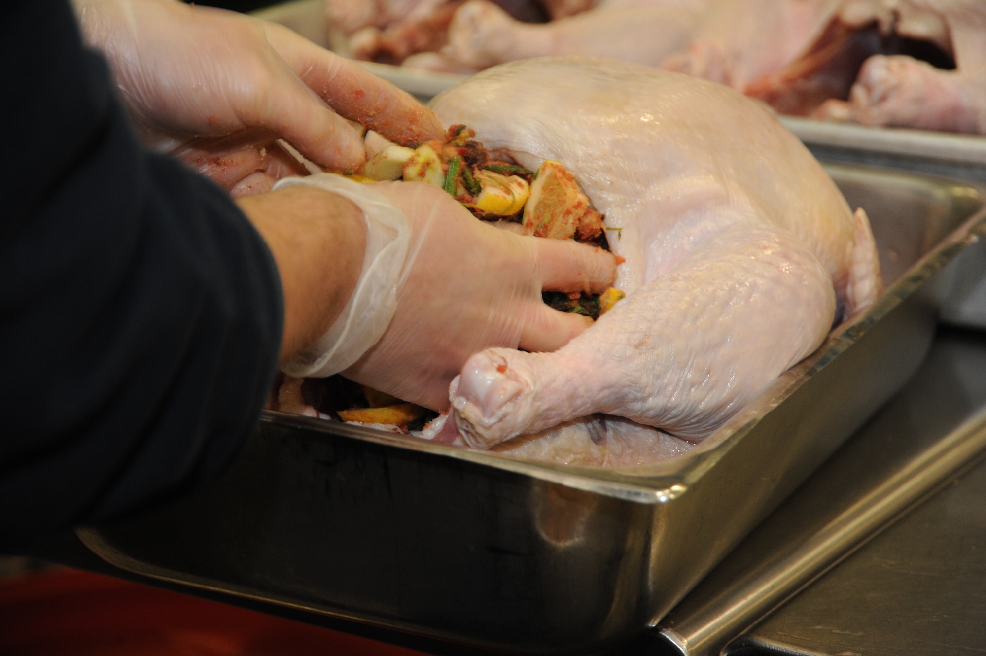 SPANGDAHLEM AIR BASE, Germany-- Dennis Tautges, a chef for the 52nd Force Support Squadron, stuffs a turkey in preparation for a Thanksgiving day meal Nov. 28, 2013, at the Mosel Hall Dining Facility.  The turkey, along with other main courses, served for more than 150 Airmen and their families. (U.S. Air Force photo by Airman 1st Class Dylan Nuckolls/Released)