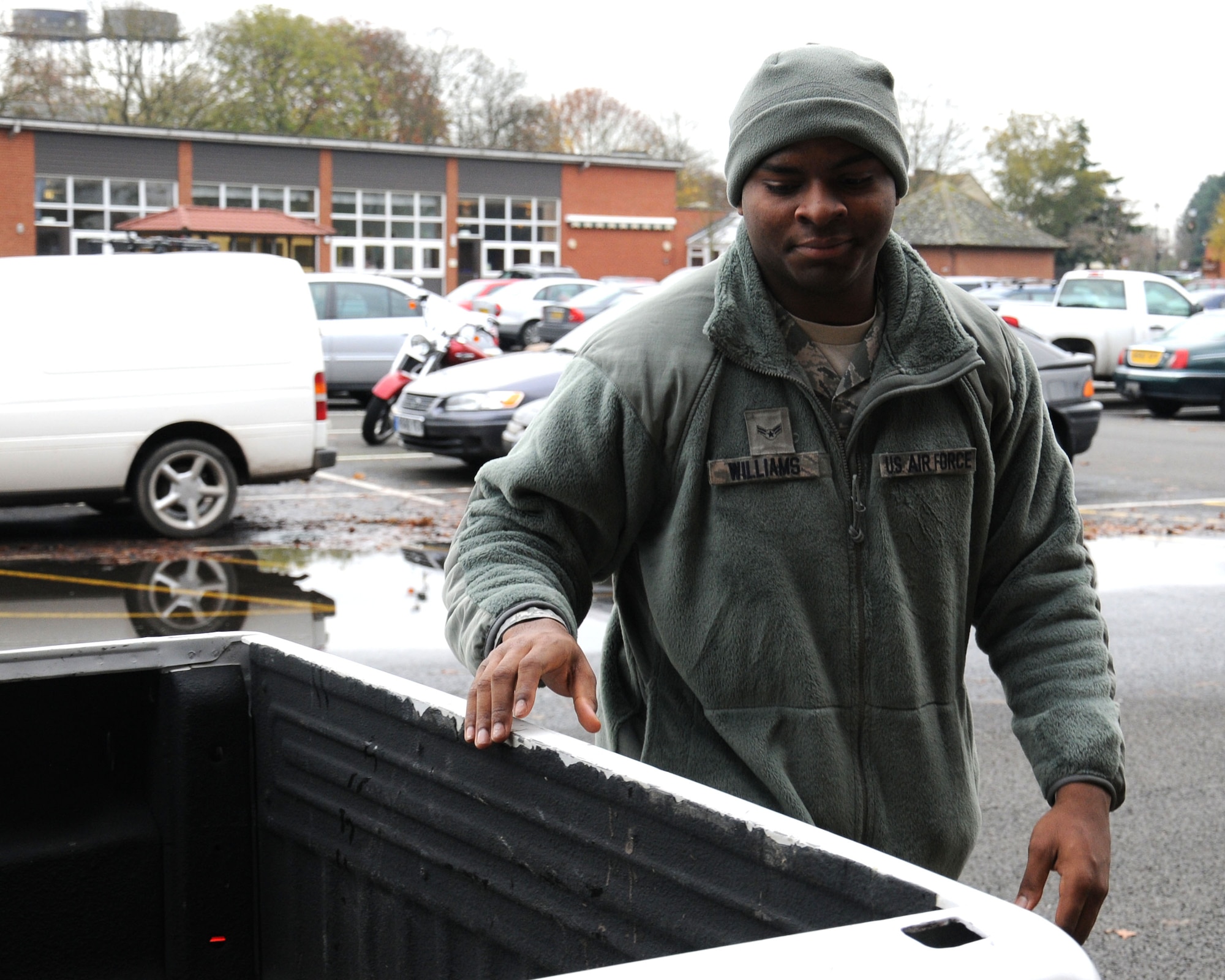 U.S. Air Force Airman 1st Class Johnarius Williams, 100th Aircraft Maintenance Squadron Aerospace Maintenance apprentice from Augusta, Ga., removes equipment and furniture from a truck Nov. 26, 2013, on RAF Mildenhall, England. The furniture was moved to make a lounge for the Airmen Against Drunk Driving volunteers while on duty. There are currently 460 airmen residing in the dormitories which is one area the AADD program supports. (U.S. Air Force photo by Gina Randall/Released) 