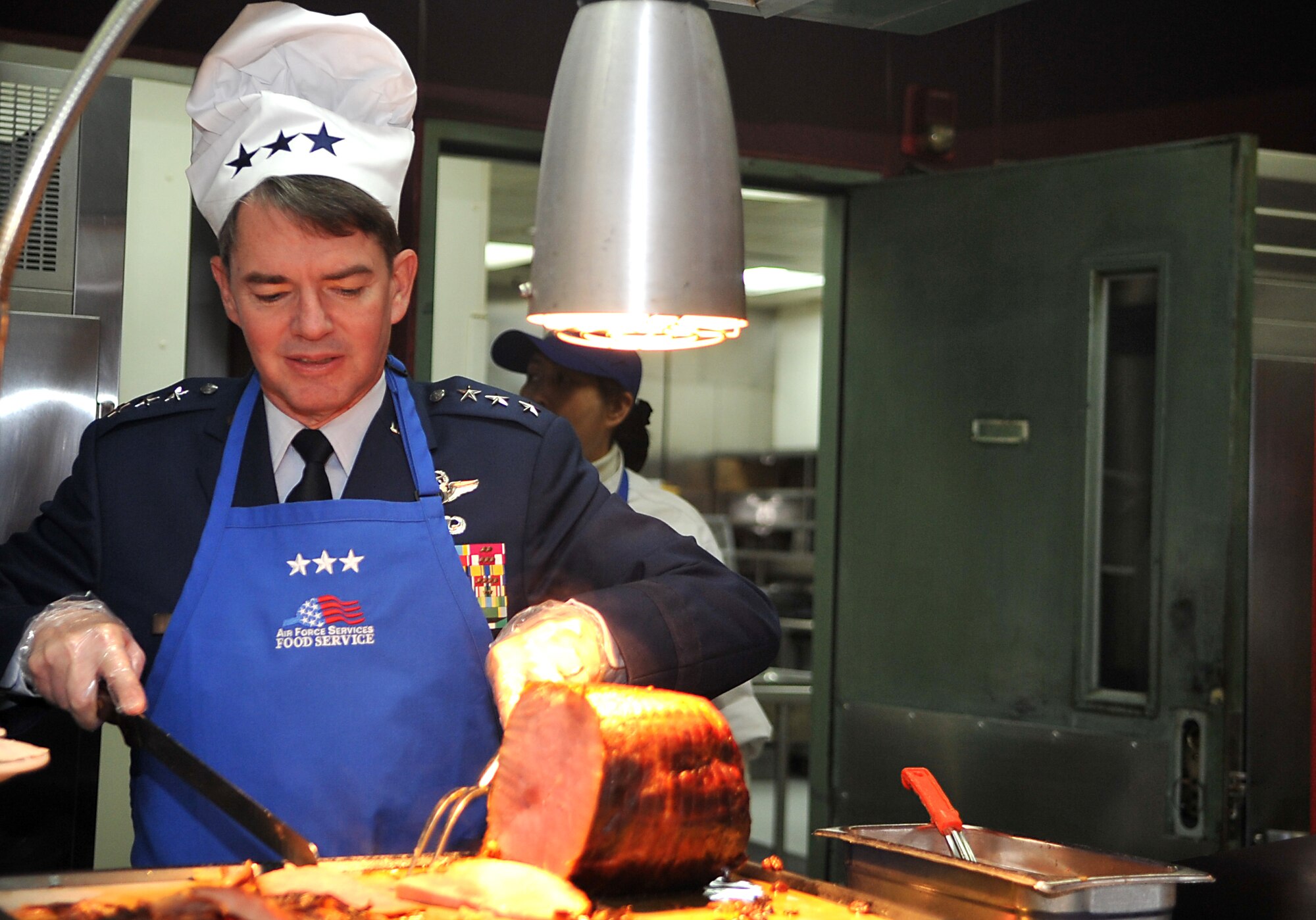 Lt. Gen. Jan-Marc Jouas, 7th Air Force commander, carves slices of ham during the Thanksgiving meal in the Gingko Tree dining facility at Osan Air Base, Republic of Korea, Nov. 28, 2013. Airmen and Soldiers were able to choose from a full range of Thanksgiving favorites including turkey, ham, vegetables, egg nog and several dessert options. (U.S. Air Force photo/Airman 1st Class Ashley J. Thum)