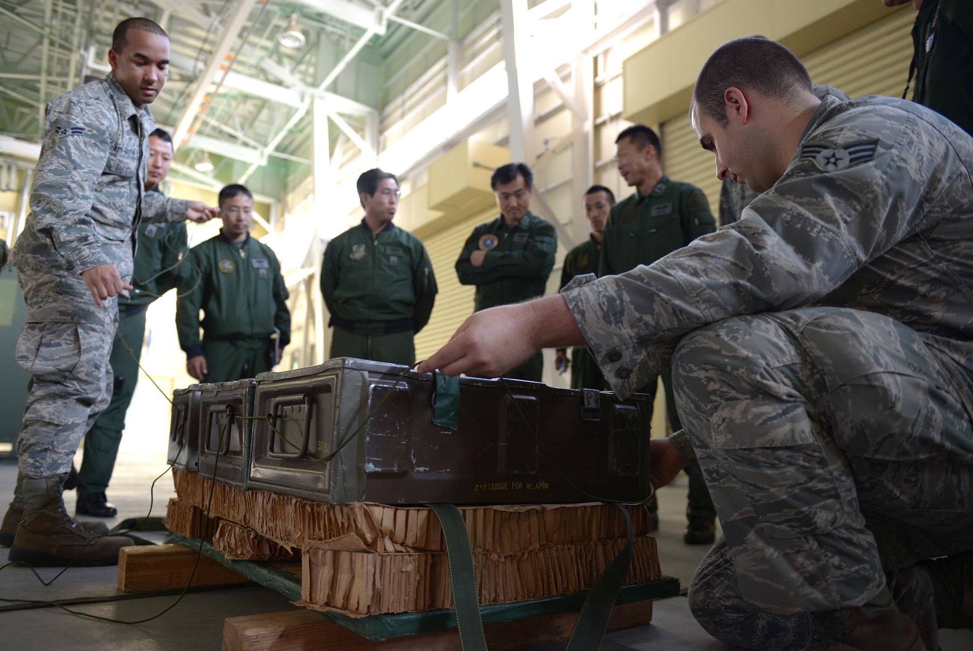 Airmen instruct members of the Japan Air Self-Defense Force on how to build a low-cost, low- altitude airdrop pallet at Yokota Air Base, Japan, Nov. 26, 2013. The defense force airmen hope to use techniques learned from the U.S. to build a low cost, low altitude program of their own and aid in future humanitarian assistance and disaster relief efforts. 