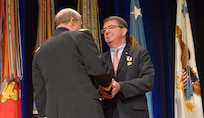 Chairman of the Joint Chiefs of Staff Martin E. Dempsey congratulates outgoing Deputy Secretary of Defense Ashton B. Carter after awarding him the Distinguished Civilian Service Medal during a farewell ceremony for Carter in the Pentagon Auditorium Dec. 2, 2013. DoD photo by Glenn Fawcett (Released)