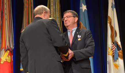 Chairman of the Joint Chiefs of Staff Martin E. Dempsey congratulates outgoing Deputy Secretary of Defense Ashton B. Carter after awarding him the Distinguished Civilian Service Medal during a farewell ceremony for Carter in the Pentagon Auditorium Dec. 2, 2013. DoD photo by Glenn Fawcett (Released)