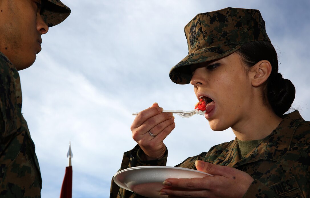 Pfc. Jennifer Carrillo, right, power lines mechanic, Marine Aviation Logistics Squadron (MALS) 11, takes a bite of cake during a cake-cutting ceremony aboard Marine Corps Air Station Miramar, Calif., Dec. 2. The Marines in the squadron celebrated its 92nd anniversary by sharing its history and cake.