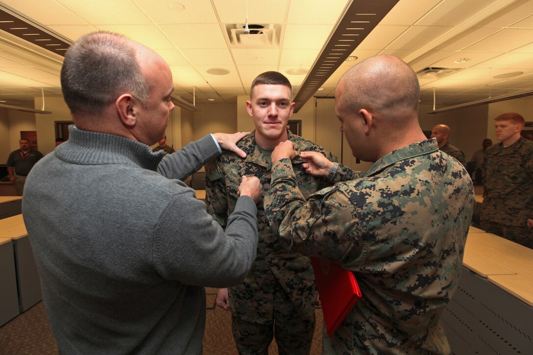Marines and Civilians of the Marine Corps Information Operations Center gather to promote Cpl Russell D. Harned to the rank of Sergeant. Sergeant Harned was pinned on by Mr. Jonathan M. Storment and GySgt John C. Tyson. (U.S. Marine Corps photo by Sgt Kristofer Atkinson)