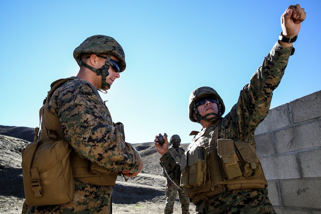 Corporal Jacob Martinez, right, administrative specialist, 15th Marine Expeditionary Unit, practices throwing a training grenade while Sgt. Lewis Craparotta, special intelligence systems administrator, 15th MEU, ensures proper technique during a small-arms training exercise at Range 109 aboard Camp Pendleton, Calif., Nov. 25. The training focused on enhancing the unit’s confidence and proficiency with personal weapons and M67 Fragmentation Hand Grenades. Martinez, 23, is from Houston. Craparotta, 24, is from San Clemente, Calif. (U.S. Marine Corps photo by Cpl. Emmanuel Ramos)