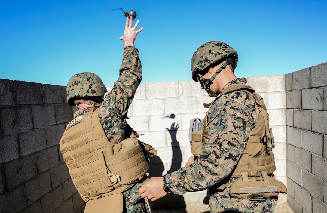 Sergeant Jonathan Ayala, left, cyber network operator, 15th Marine Expeditionary Unit, practices throwing a training grenade while Sgt. Lewis Craparotta, special intelligence systems administrator, 15th MEU, ensures proper technique during a small-arms training exercise at Range 109 aboard Camp Pendleton, Calif., Nov. 25. The training focused on enhancing the unit’s confidence and proficiency with personal weapons and M67 Fragmentation Hand Grenades. Ayala, 22, Providence, R.I. Craparotta, 24, is from San Clemente, Calif. (U.S. Marine Corps photo by Cpl. Emmanuel Ramos)