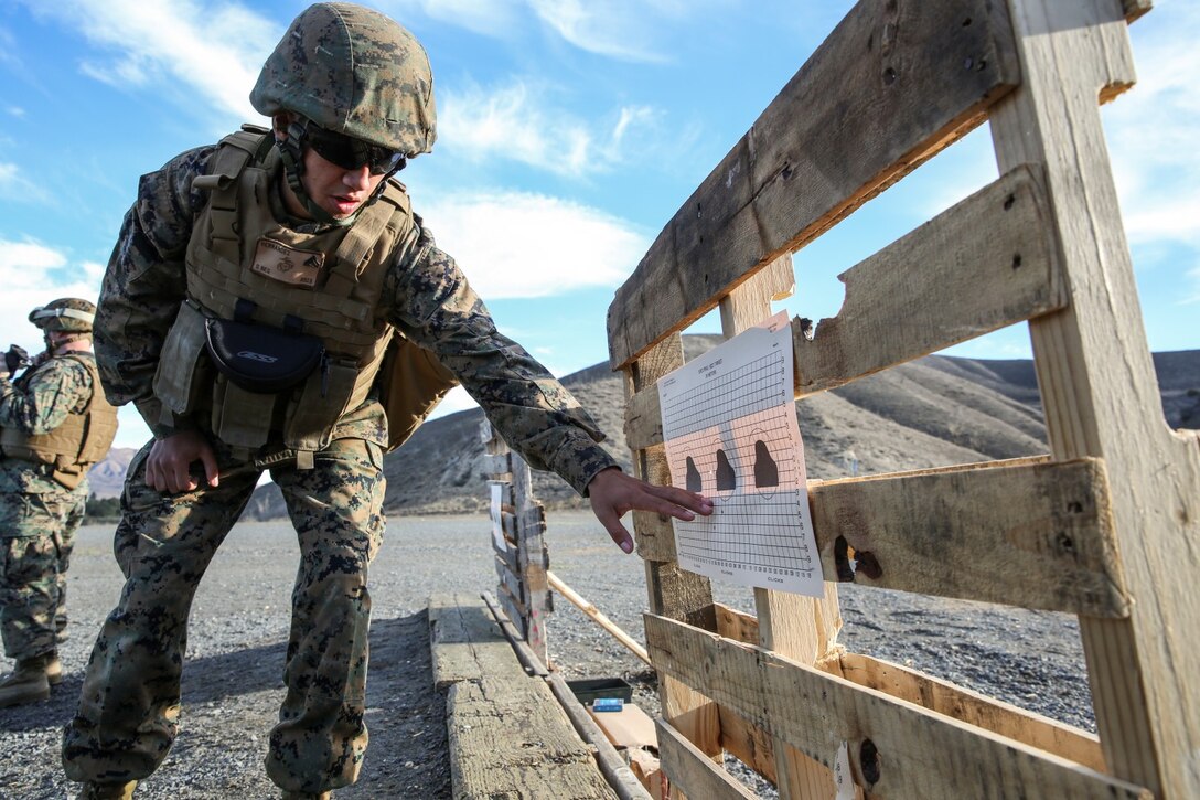 Corporal Richard Hernandez, data network specialist, 15th Marine Expeditionary Unit, makes calculations to help  a Marine attain his battle sight zero during a small-arms training exercise at Range 111 aboard Camp Pendleton, Calif., Nov. 25. The training focused on enhancing the unit’s confidence and proficiency with personal weapons and M67 Fragmentation Hand Grenades. Hernandez, 22, is from Temecula, Calif. (U.S. Marine Corps photo by Cpl. Emmanuel Ramos)