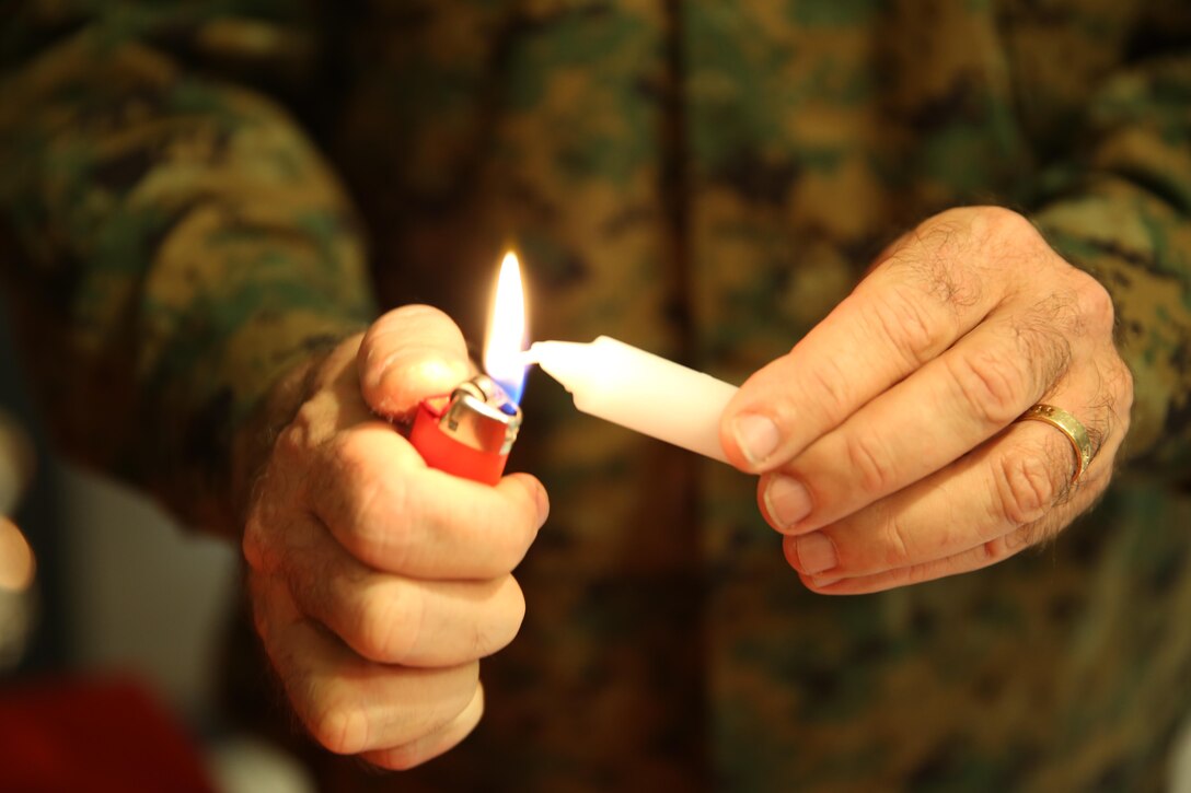 Capt. Irving Elson, a chaplain with I Marine Expeditionary Force, lights the shamash, or “attendant” candle for a Hanukkah menorah lighting aboard Marine Corps Air Station Miramar, Calif., Dec. 2. Elson used the shamash to light the remaining candles as part of a tradition in the holiday. 