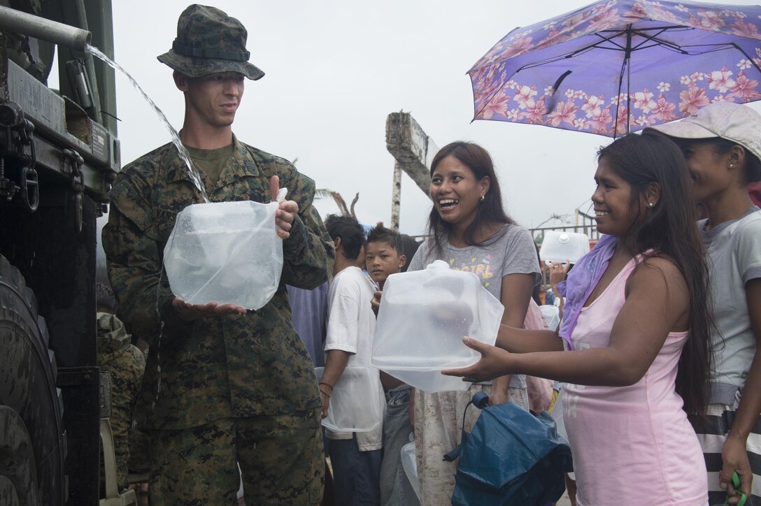 U.S. Marine Staff Sgt. James Van Sickel assigned to Combat Logistics Battalion 4 (CLB 4) gives water to Palo residents affected by Typhoon Haiyan during a water distribution operation. CLB 4 is part of Joint Task Force 505 in support of Operation Damayan.