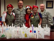 From left: Jennifer Roscoe; Col. Johnny Roscoe, 15th Wing commander; Gwen Omori, Friends of Hickam; Kat Scott; and Col. Terry Scott, 15th Wing vice commander, volunteer for and support the annual Cookie Caper event Dec. 3, 2013. The cookies are distributed to single Airmen living in the base dormitories. The cookie drive collected 16,176 cookies and distributed bags to more than 1,300 Airmen. (U.S. Air Force photo/Staff Sgt. Alexander Martinez) 