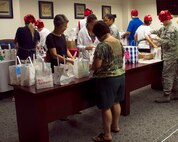Cookie Caper “elves” collect and sort cookies in holiday-themed bags during the annual Cookie Caper event Dec. 3, 2013. The cookies are distributed to single Airmen living in the base dormitories. The cookie drive collected 16,176 cookies and distributed bags to more than 1,300 Airmen. (U.S. Air Force photo/Staff Sgt. Alexander Martinez)