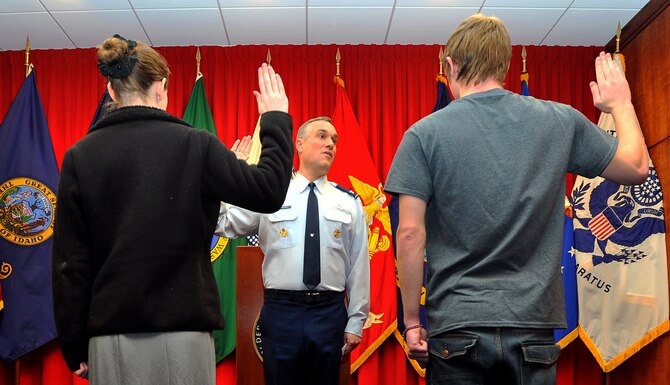 Col. Brian Newberry, 92nd Air Refueling Wing commander, swears Jessica Kraus and Damion Loringer into the U.S. Air Force at the U.S. Military Entrance Processing Station in Airway Heights, Wash., Dec. 3, 2013. Loringer is from Spokane Wash., and Kraus hails from Post Falls, Idaho. (U.S. Air Force photo by Staff Sgt. Veronica Montes/Released)