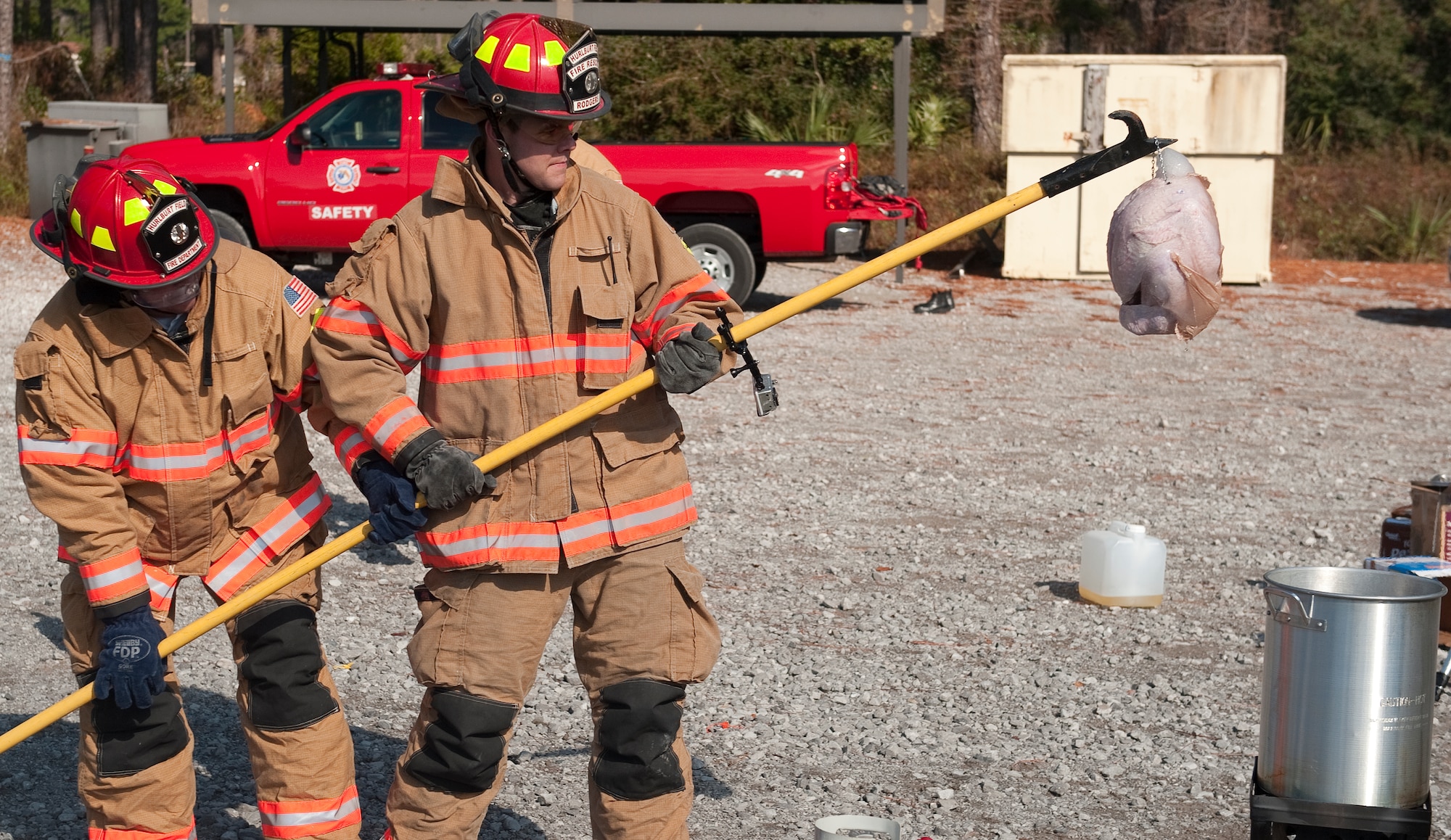 Firefighters from the 1st Special Operations Civil Engineer Squadron prepare to fry a turkey during a safety demonstration at the fire training area on Hurlburt Field, Fla., Nov. 27, 2013. Maintaining a safe distance from buildings and other flammable objects and not overfilling a turkey fryer can prevent potential fires. (U.S. Air Force photo/Senior Airman Kentavist P. Brackin)
