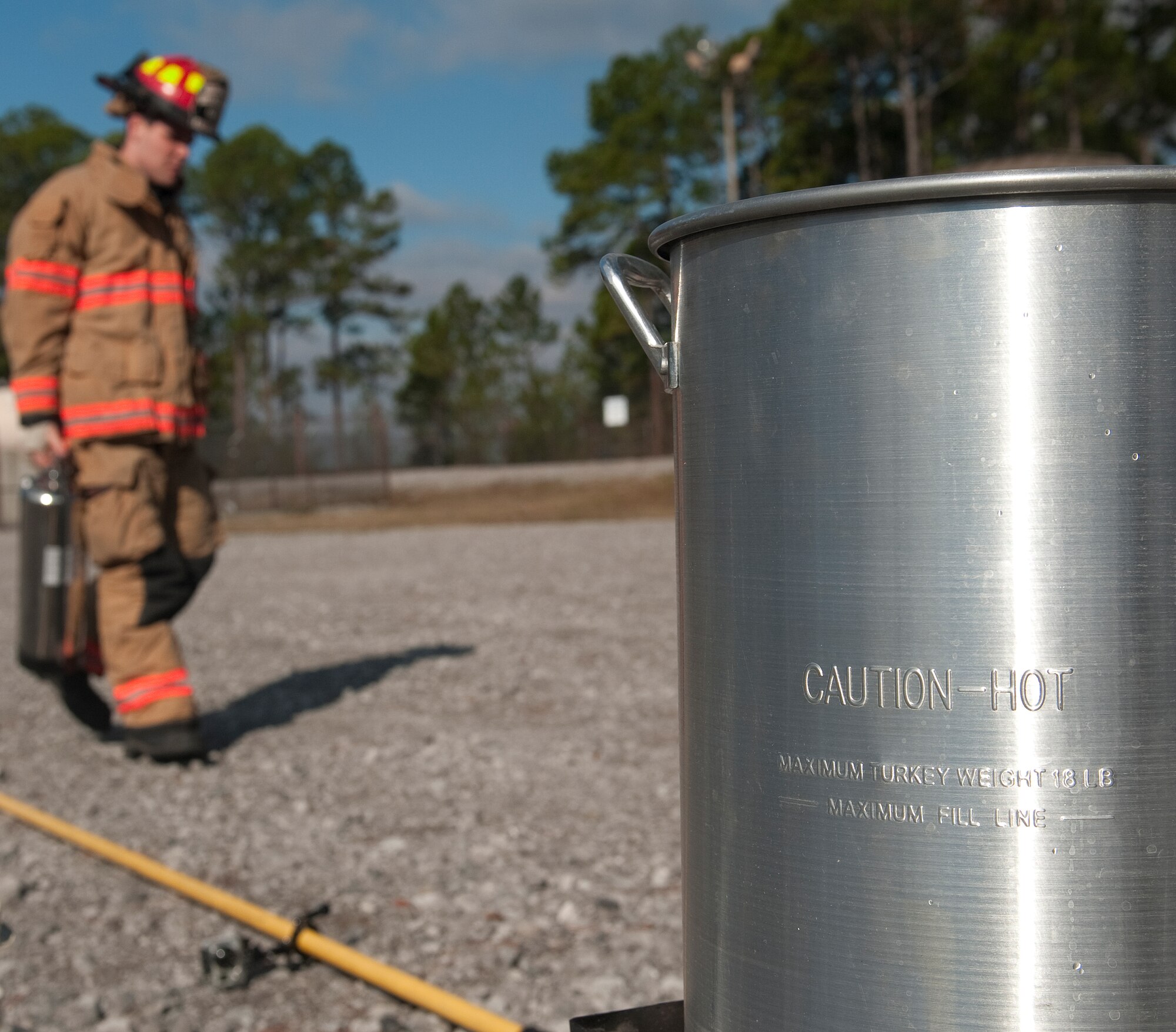A firefighter from the 1st Special Operations Civil Engineer Squadron prepares to extinguish a turkey fryer fire during a safety demonstration at the fire training area on Hurlburt Field, Fla., Nov. 27, 2013. Maintaining a safe distance from buildings, flammable objects, and not overfilling a turkey fryer can prevent potential fires. (U.S. Air Force photo/Senior Airman Kentavist P. Brackin)