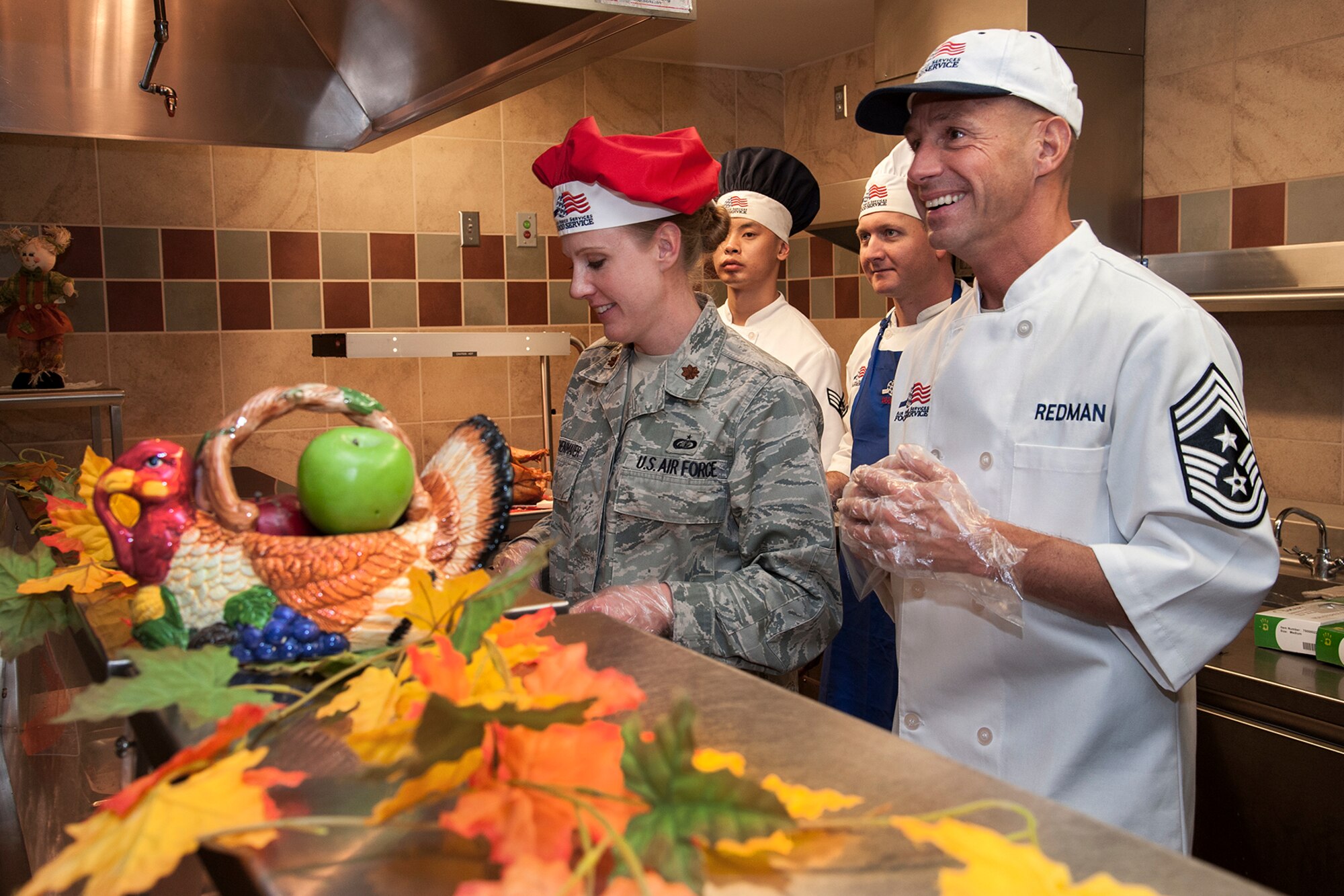 PETERSON AIR FORCE BASE, Colo. -- Maj. Tammy Schlichenmaier (left), 21st Force Support Squadron commander, and Chief Master Sgt. Richard Redman, 21st Space Wing command chief, serve a holiday meal Nov. 22 at the Aragon Dining Facility. The annual meal featured traditional holiday favorites and drew about 300 diners. (U.S. Air Force photo/Craig Denton)
