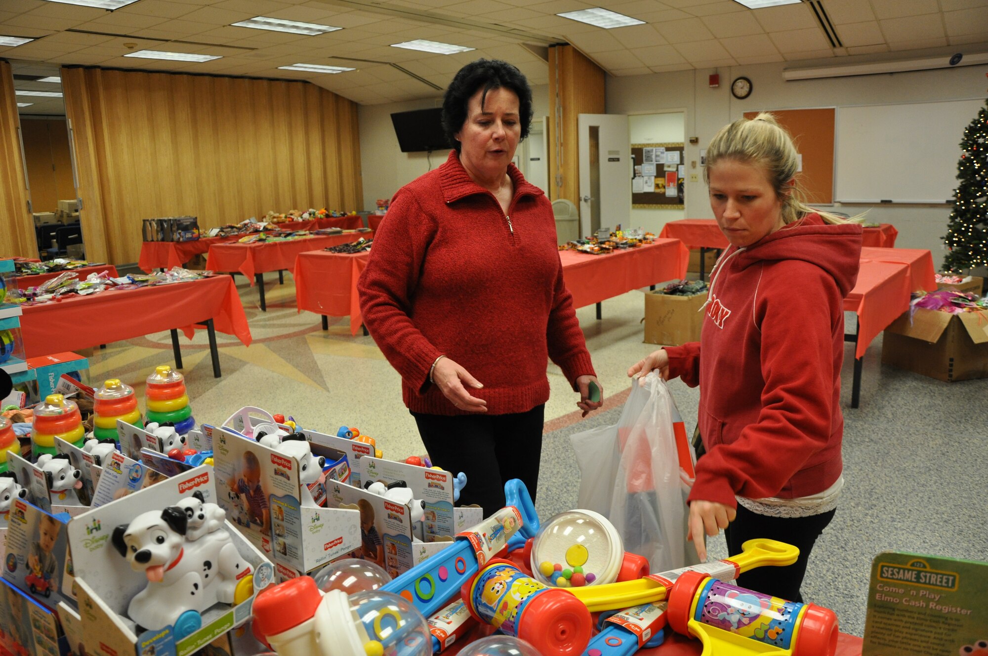PETERSON AIR FORCE BASE, Colo. – Michele Quartullo (left), an Operation Homefront volunteer, helps Brittany Brown, a family member, pick out Christmas presents for her children Dec. 2 at the Peterson Chapel. Brown and her husband were one of approximately 784 area families to receive help from the Operation Homefront - Rocky Mountains’ Holiday Toys for Military event. Parents were able to pick out one premium gift per child and 15 smaller stocking stuffer items. In addition, each family received a gift card for holiday meals. To register for future events, or for more information, visit www.operationhomefront.com. (U.S. Air Force photo/Tech. Sgt. Jared Marquis)