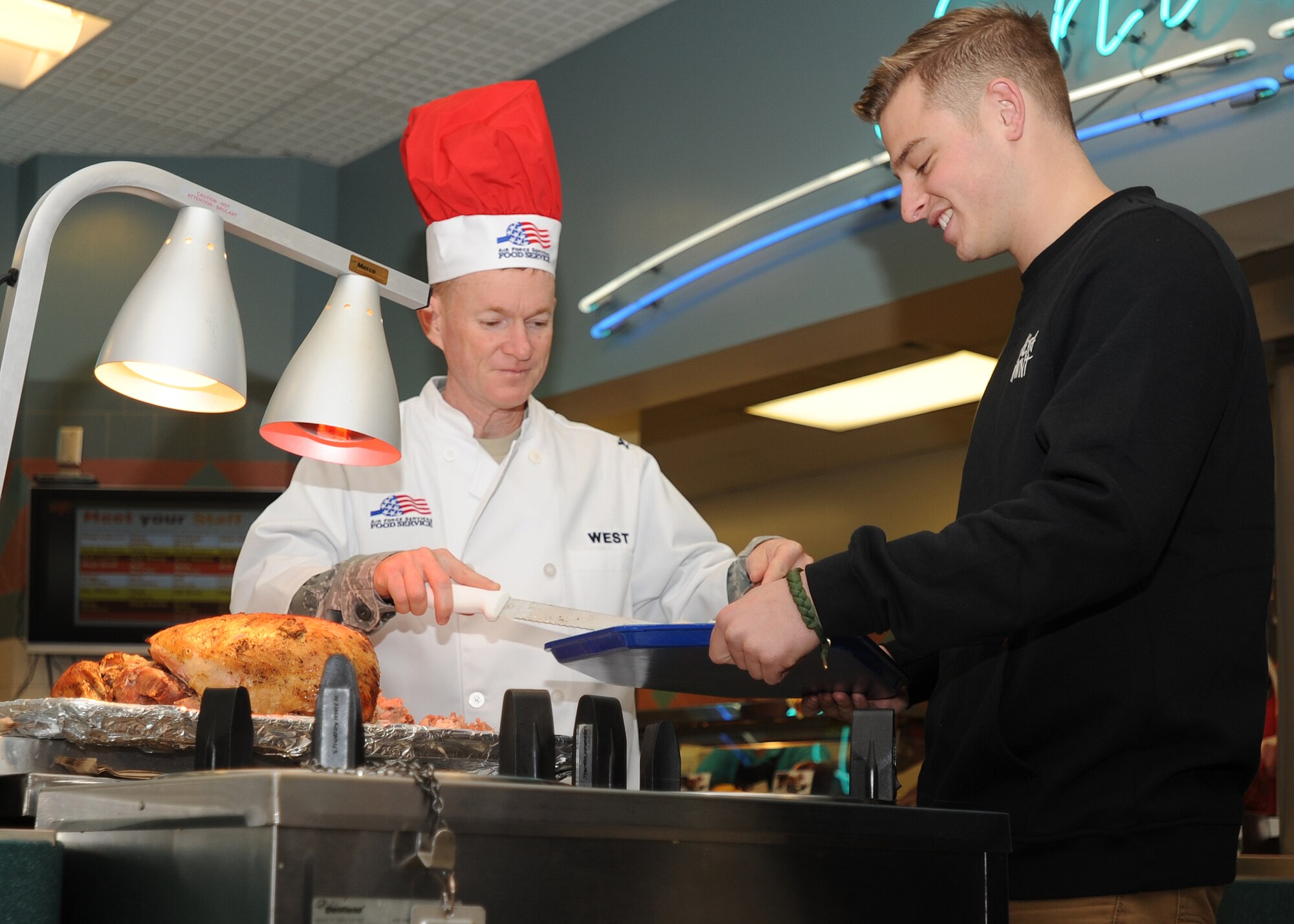 Col. William West, 1st Special Operations Wing commander, serves a slice of turkey to Airman 1st Class Jake Holtz, 15th Aircraft Maintenance Unit aerospace propulsion journeyman, during the Thanksgiving meal at the Riptide Dining Facility on Hurlburt Field, Fla., Nov. 28, 2013. More than 200 Air Commandos, retirees and their family members attended the meal. (U.S. Air Force photo/Senior Airman Kentavist P. Brackin)