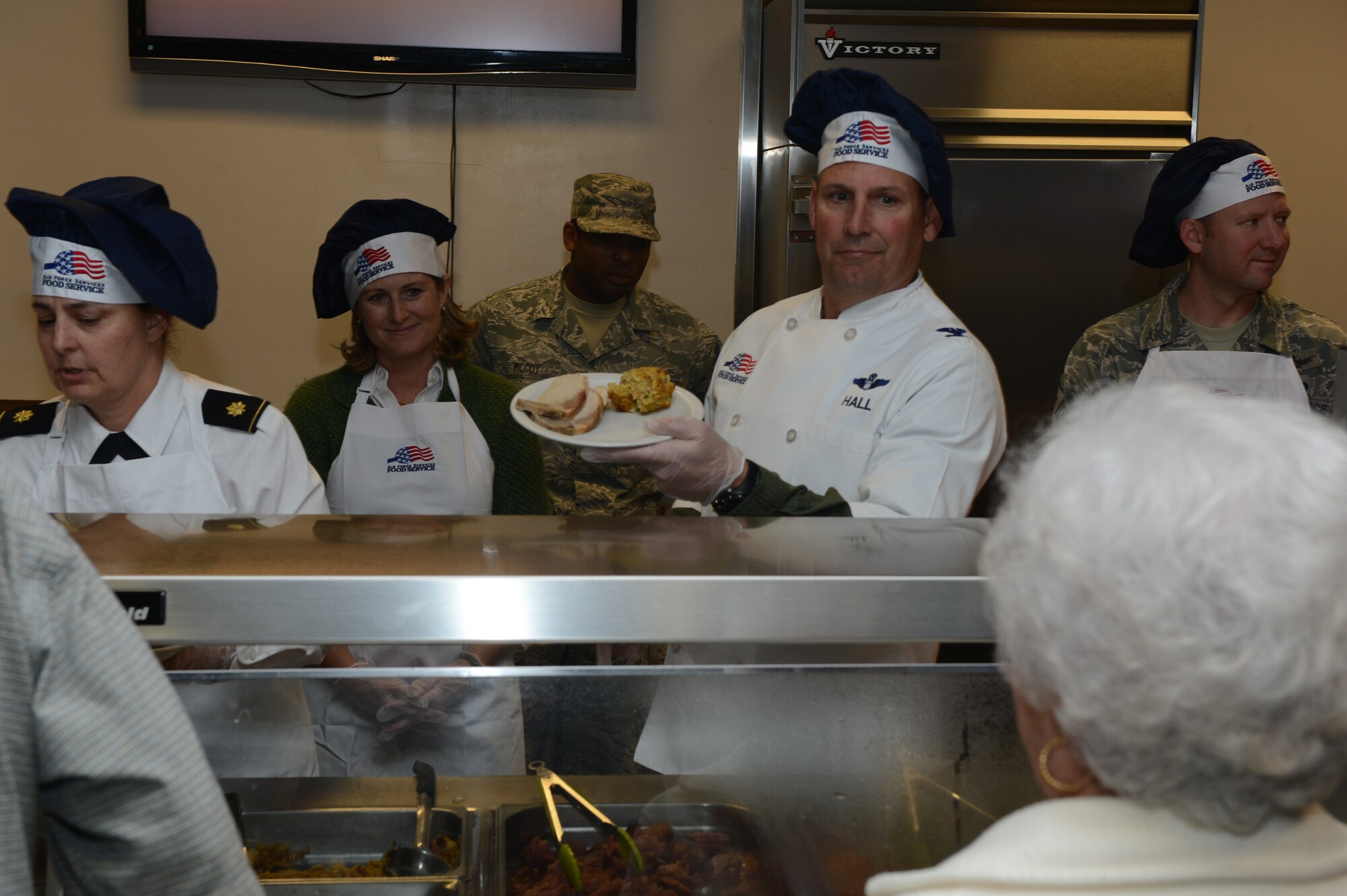 U.S. Air Force Col. Clay Hall, 20th Fighter Wing commander, serves a home cooked meal to patrons at the Chief Master Sergeant Emerson E. Williams Dining Facility, Nov. 28, 2013, Shaw Air Force Base, S.C. Hall spent his day working with Airmen and civilians at the dining facility to serve Thanksgiving meals to 266 guests. (U.S. Air Force photo by Tech. Sgt. Frank Miller/Released)
