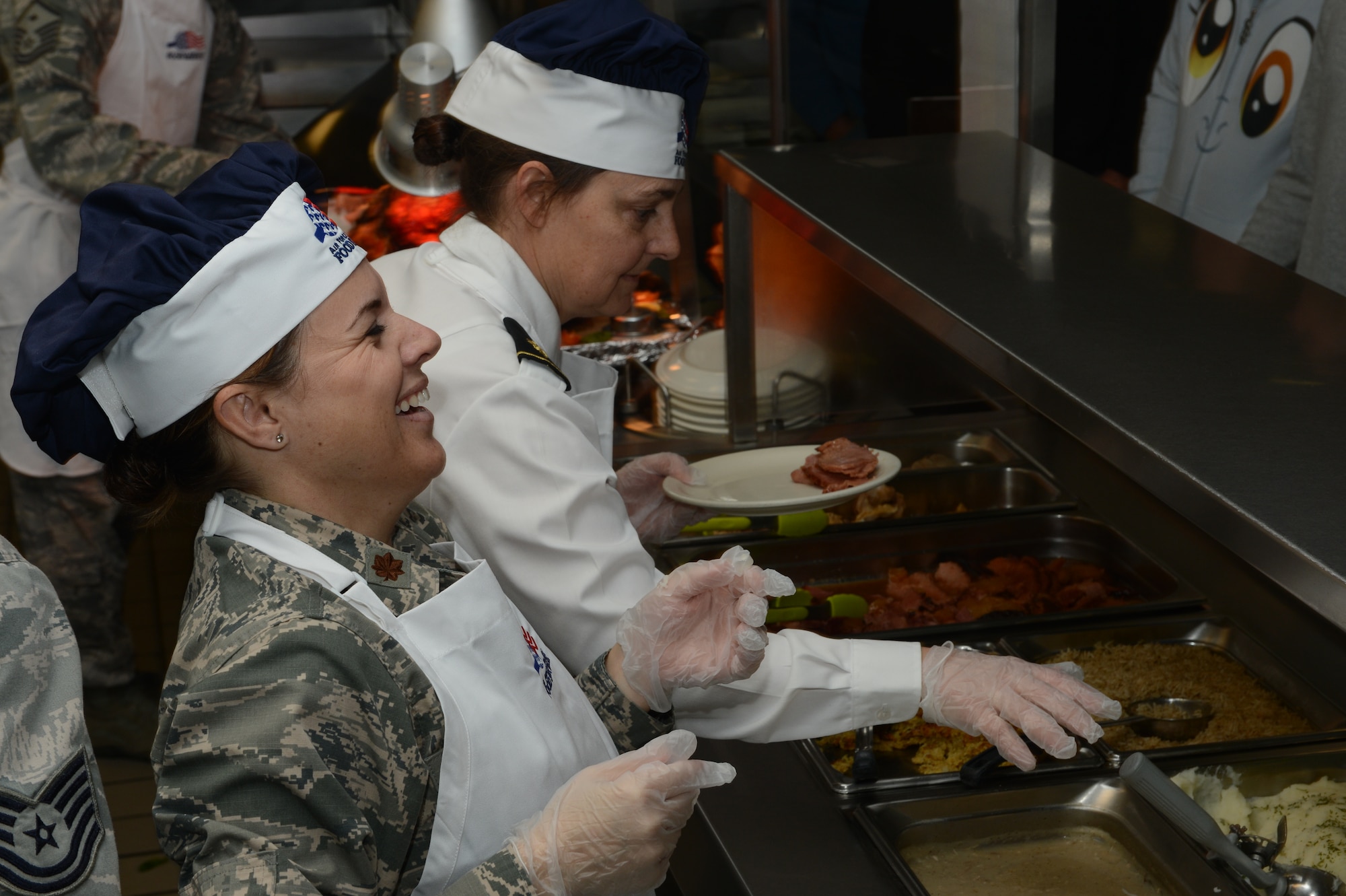 U.S. Air Force Major Jamie Wade, 20th Logistics Readiness Squadron commander, laughs  while serving food at the Chief Master Sergeant Emerson E. Williams Dining Facility, Nov. 28, 2013, Shaw Air Force Base, S.C. Wade assisted in serving 266 Airmen, dependents and retirees during the Thanksgiving meal. (U.S. Air Force photo by Tech. Sgt. Frank Miller/Released)