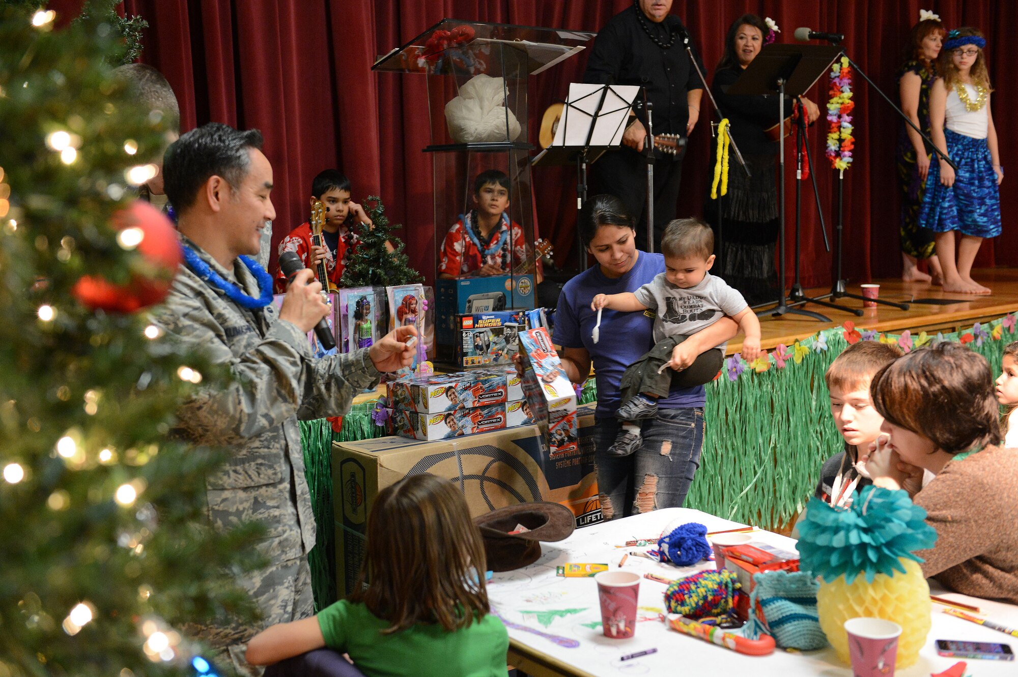Col. David Kumashiro, 62nd Airlift Wing commander, announces raffle winners at the quarterly deployed families dinner Dec. 2, 2013, at Joint Base Lewis-McChord, Wash. The night’s raffle prizes included dolls, a game console and a basketball hoop. (U.S. Air Force photo/Staff Sgt. Jason Truskowski)  