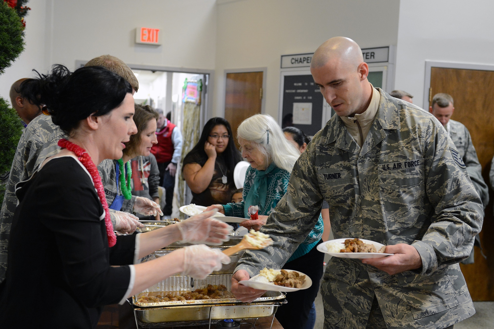 Staff Sgt. Jason Truner, 627th Force Support Squadron outbound assignment NCO in charge, gets served a plate at the quarterly deployed families dinner, Dec. 2, 2013 at Joint Base Lewis-McChord, Wash. Commanders and first sergeants served families throughout the dinner. (U.S. Air Force photo/Airman 1st Class Jacob Jimenez)   
