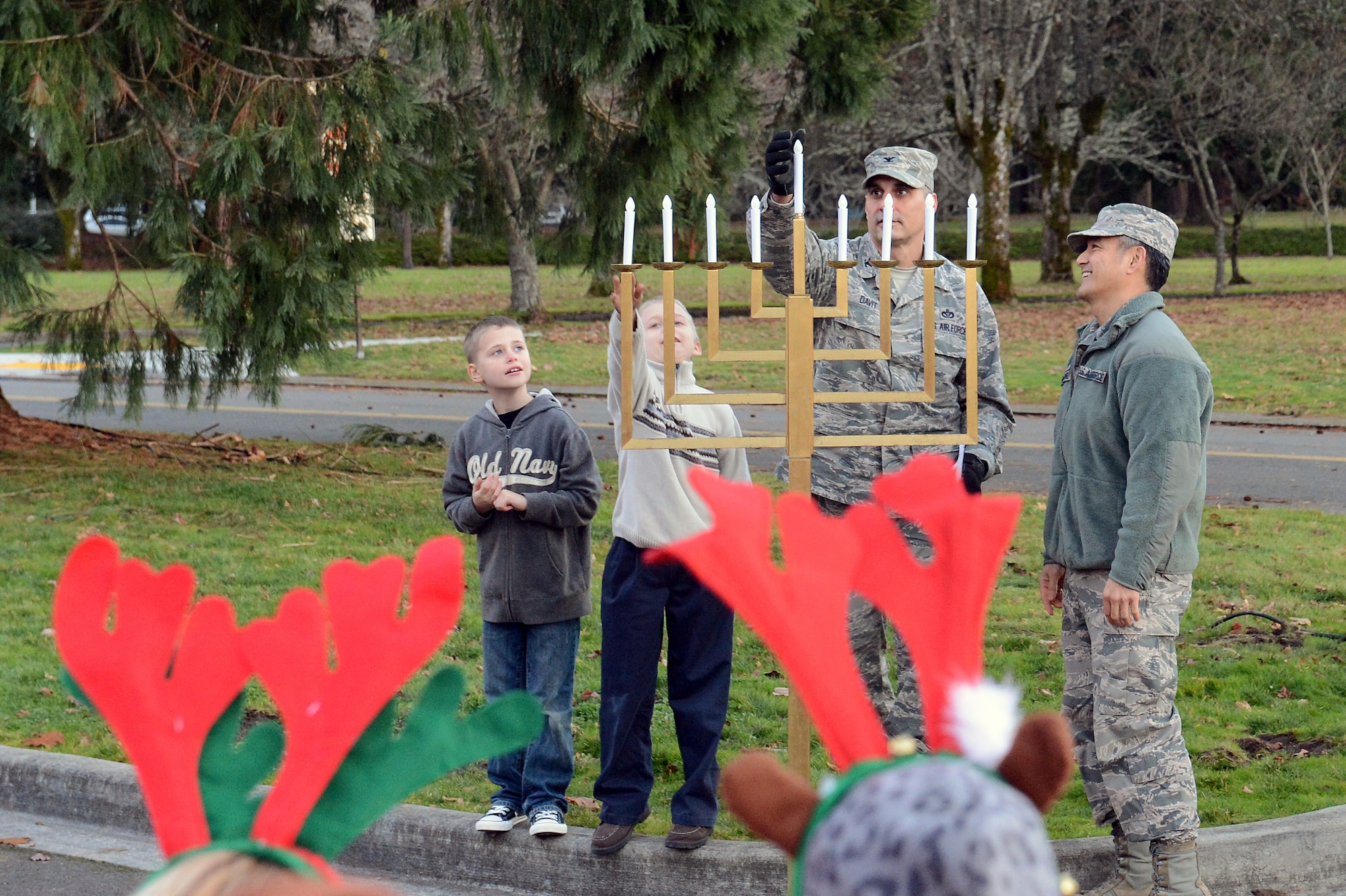 Col. Anthony Davit, 627th Air Base Group commander, and Col. David Kumashiro, 62nd Airlift Wing commander, with the help of two children light a menorah Dec. 2, 2013, at the annual tree lighting ceremony at Joint Base Lewis-McChord, Wash. The Menorah was lit in celebration of Hanukkah. (U.S. Air Force photo/Airman 1st Class Jacob Jimenez)