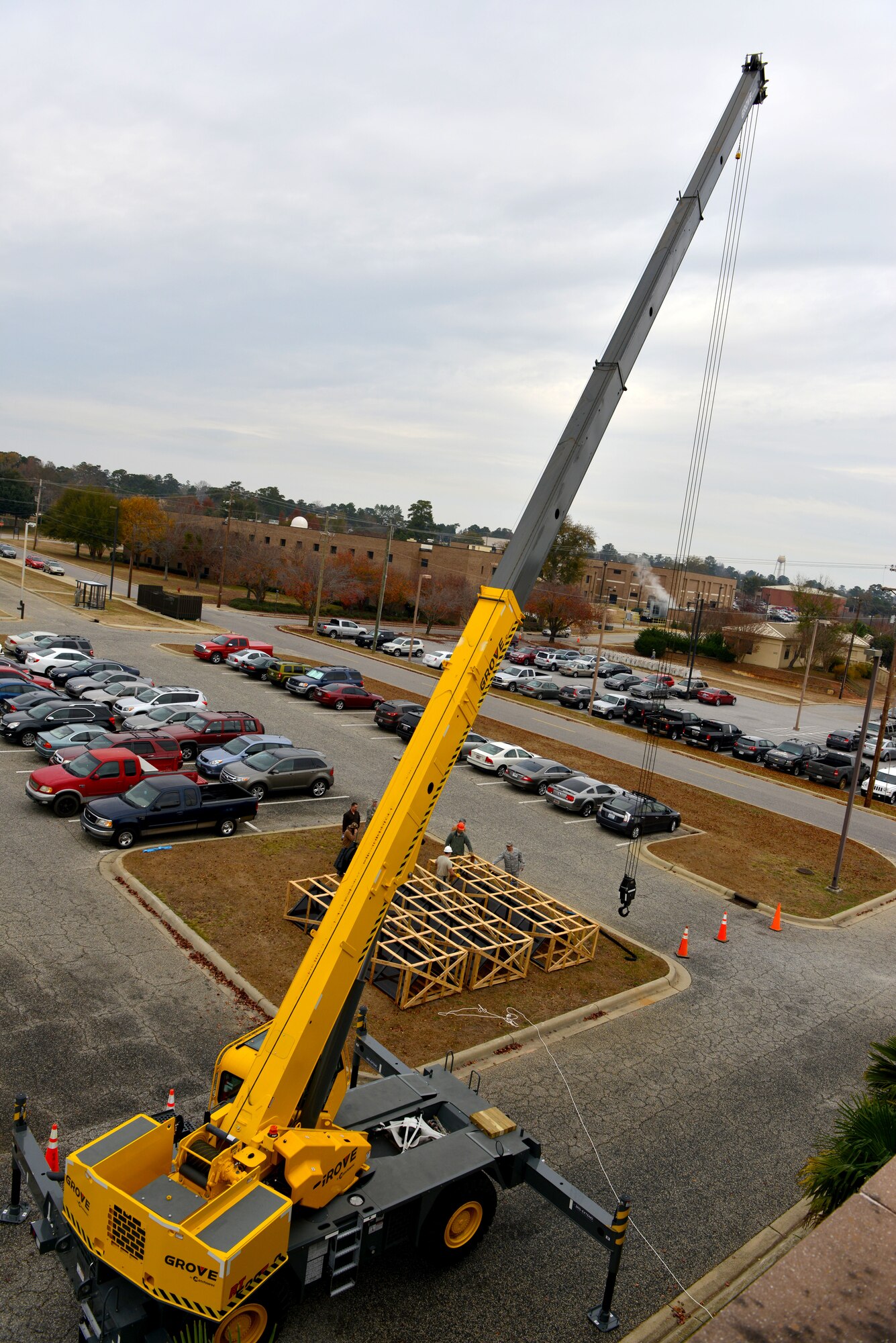 A crane sits in front of the 20th Fighter Wing Headquarters building at Shaw Air Force Base S.C., Dec. 3, 2013.  Airmen from the 20th Civil Engineering Squadron along with civilian contractors crane lifted new skylight windows onto the building to replace the old and leaking windows. (U.S. Air Force photo by Airman 1st Class Jensen Stidham/Released)