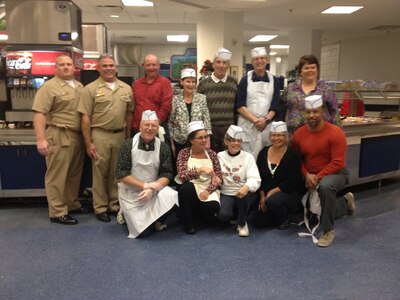 Master Chief Petty Officer Joseph Gardner, Joint Base Charleston command master chief and Capt. Timothy Sparks, JB Charleston deputy commander, join the JB Charleston - Weapons Station Galley staff and volunteers as they prepare to serve the troops Thanksgiving Dinner at the Galley, Nov. 28, 2013. (U.S. Navy photo/Lt. Cmdr. Robin Heckathorne)
