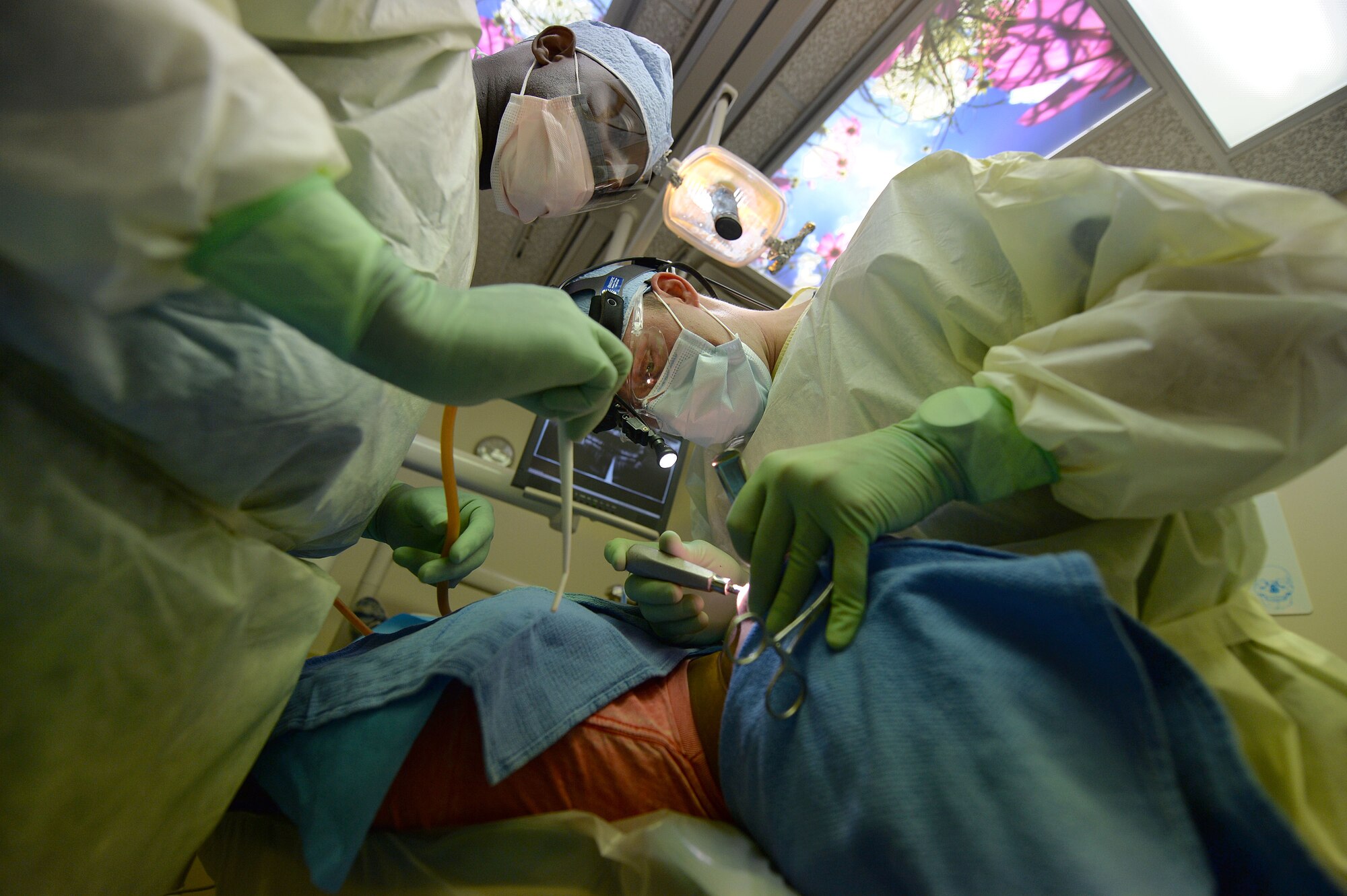 Capt. Jeff Larkin, 1st Special Operations Dental Squadron general clinical dentist, and Sherod Jones, 1st SODS dental technician, perform a wisdom tooth extraction in the dental clinic on Hurlburt Field, Fla., Nov. 19, 2013. The teeth can be taken out for several reasons, including infection, decay and cysts. (U.S. Air Force photo/Staff Sgt. Jeff Andrejcik)    