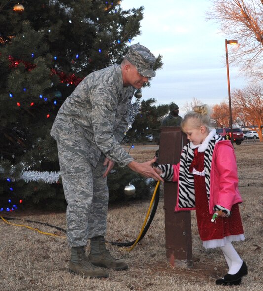 The 71st Flying Training Wing commander, Col. Darren James, thanks Baily Daniel for her help switching on the Vance Air Force Base Christmas Tree lights during a ceremony Dec. 2. (U.S. Air Force photo/ Senior Airman Frank Casciotta)