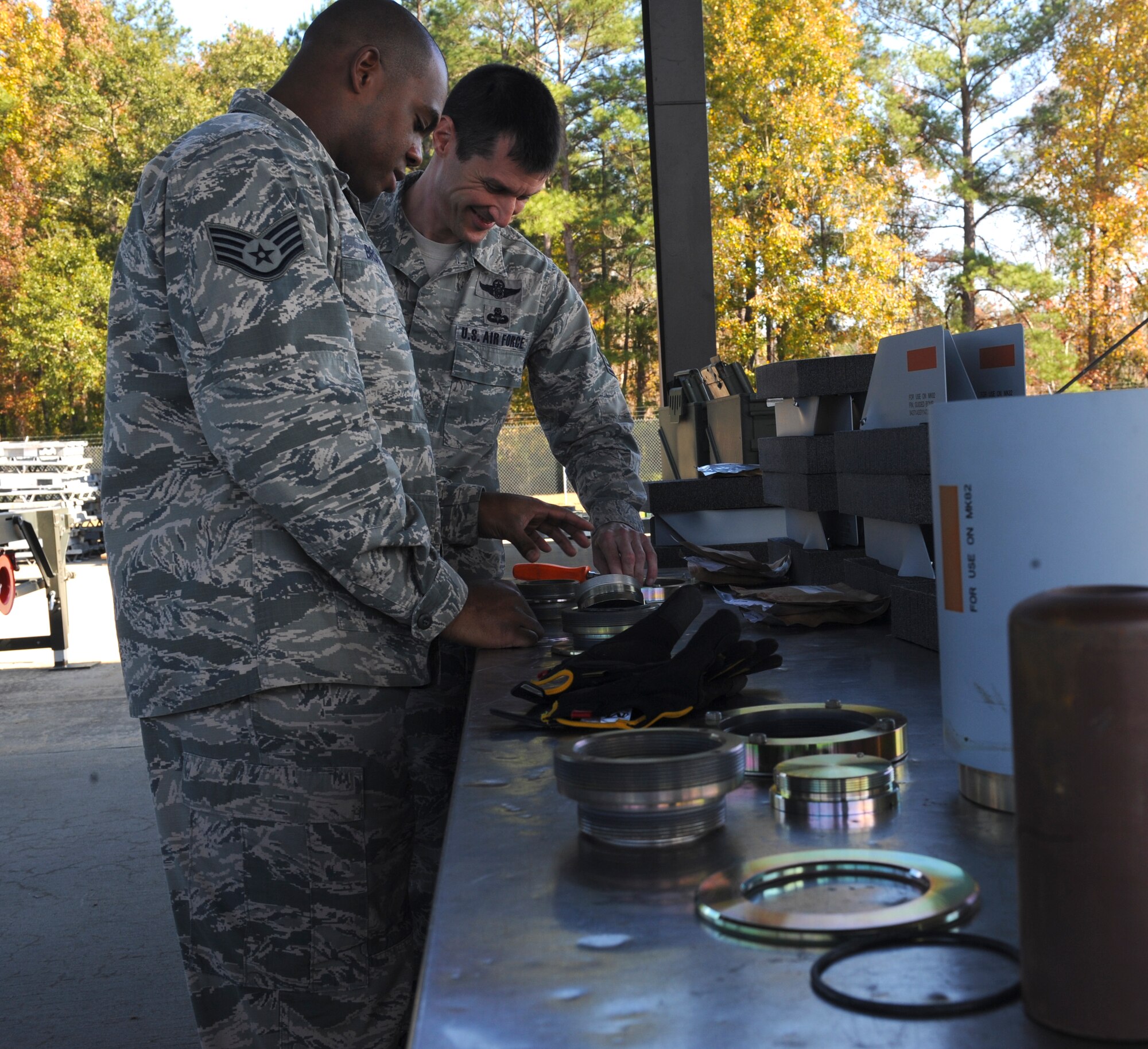 U.S. Air Force Staff Sgt. William Brown, left, 23d Equipment Maintenance Squadron munitions systems technician, shows Chief Master Sgt. Matthew Wells, 23d Wing command chief, how to assemble a forward adapter for a practice GBU-12 laser-guided bomb at Moody Air Force Base, Ga., Dec. 2, 2013. On a typical day, the 23d EMS has at least 15 people on the bomb-building assembly line. (U.S. Air Force photo by Senior Airman Olivia Bumpers/Released)