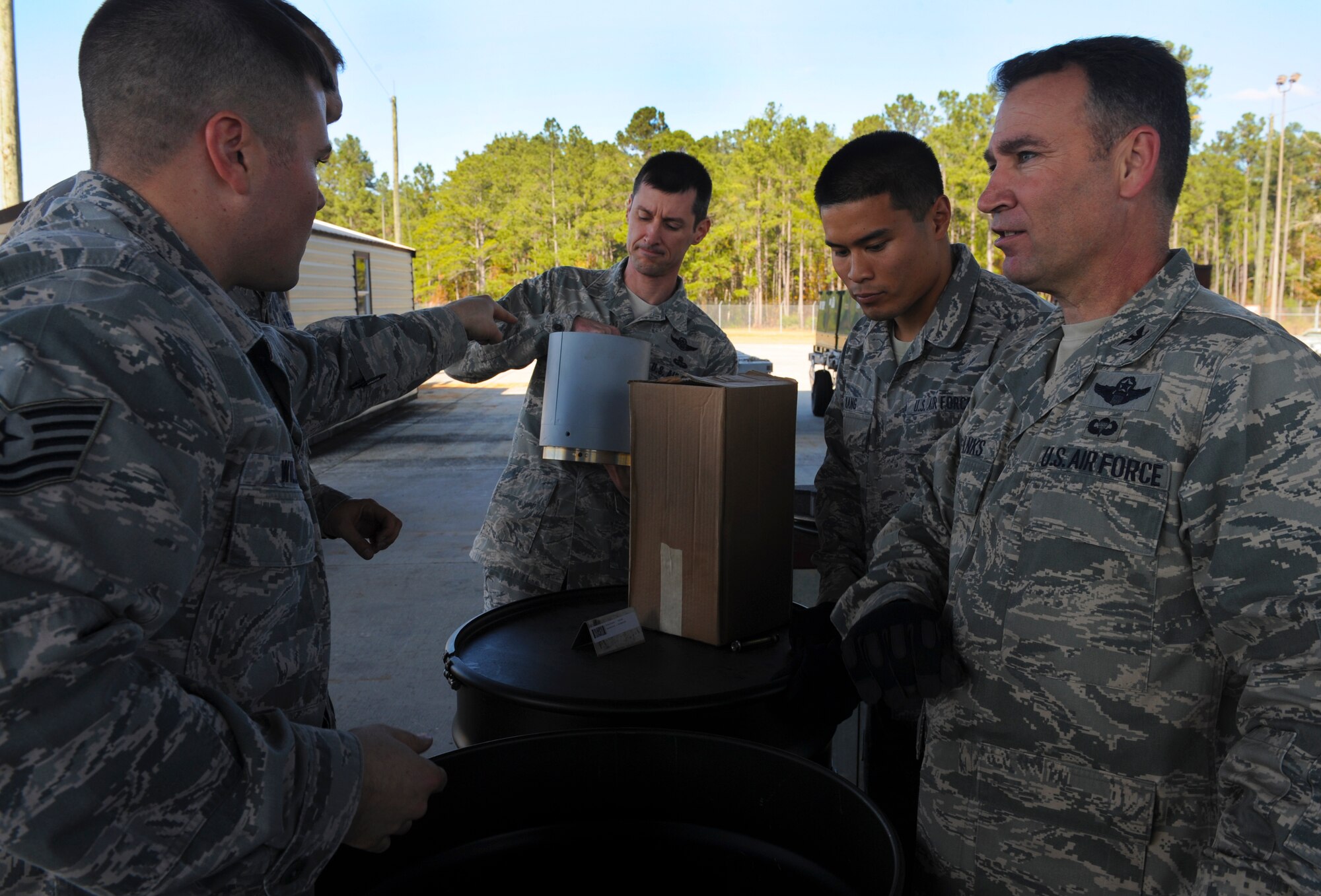 U.S. Air Force Tech. Sgt. Derek Williams, left, and Senior Airman Vattanak Kang, 23d Equipment Maintenance Squadron munitions systems technicians, brief Col. Chad Frank, 23d Wing commander, and Chief Master Sgt. Matthew Wells, 23d WG command chief, at Moody Air Force Base, Ga., Dec. 2, 2013. Franks and Wells visited the 23d EMS munitions flight to get an understanding of what they do on a daily basis. (U.S. Air Force photo by Senior Airman Olivia Bumpers/Released)