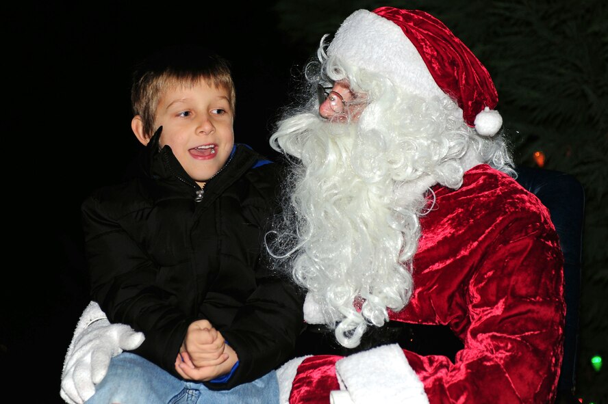 A child sits with Santa Claus during the holiday tree lighting ceremony at Seymour Johnson Air Force Base, N.C., Dec. 2, 2013. Santa assisted with the holiday tree lighting and spoke with children about their holiday wishes. (U.S. Air Force photo by Airman 1st Class John Nieves Camacho)