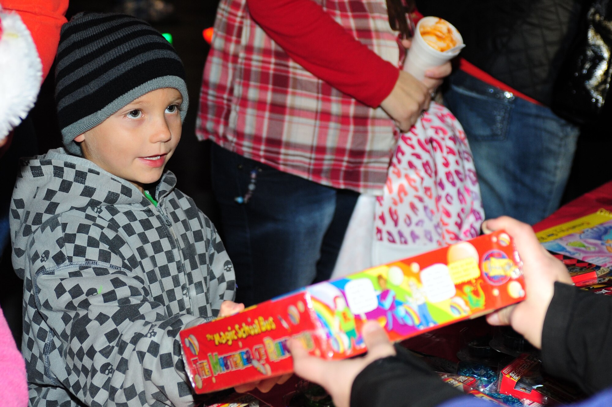 A child receives a gift during a toy-giveaway at the holiday tree lighting ceremony at Seymour Johnson Air Force Base, N.C., Dec. 2, 2013. More than 700 toys were donated to children from Toy Industry for the holidays. (U.S. Air Force photo by Airman 1st Class John Nieves Camacho)